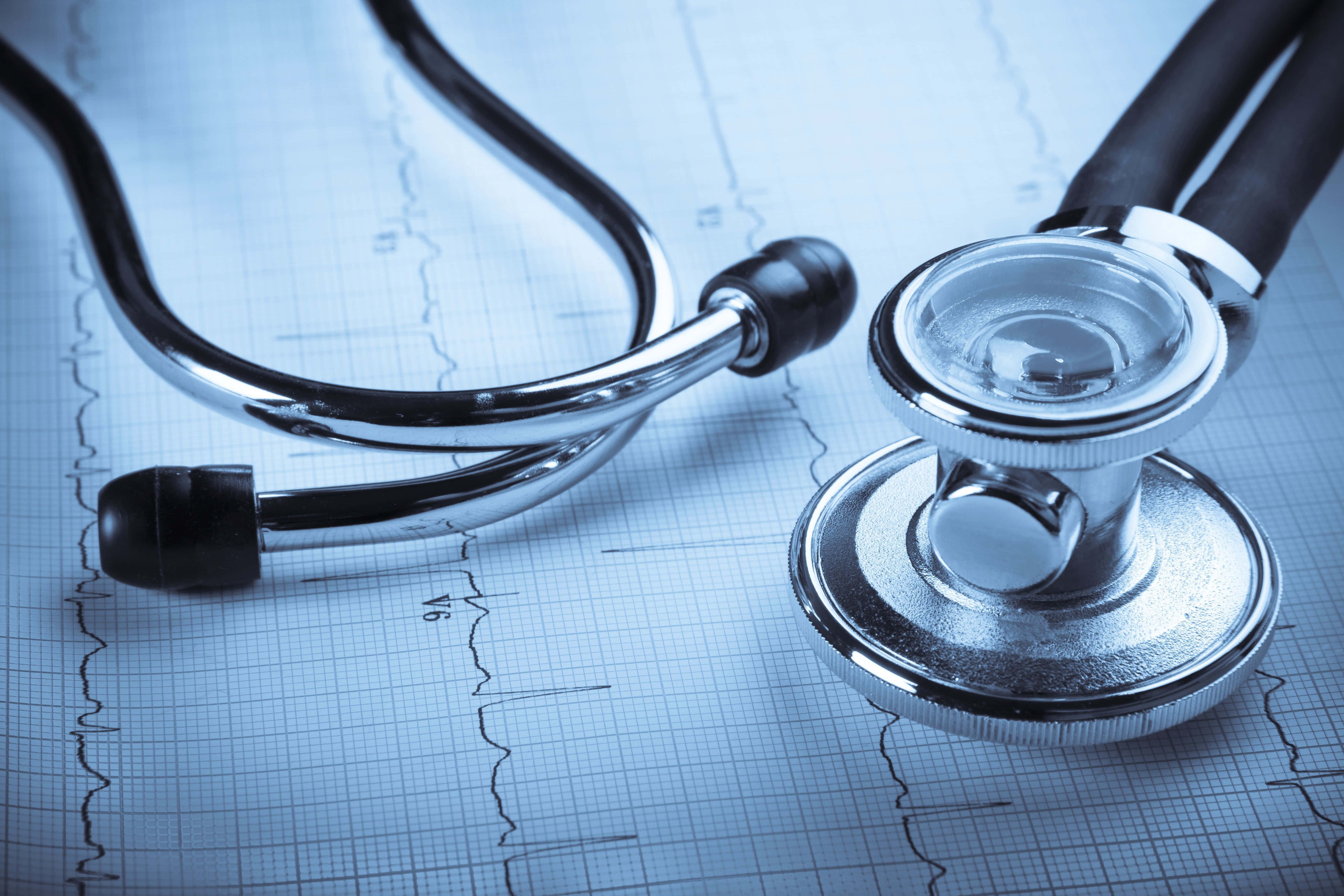 Stethoscope 桌布 壁紙 — 一個閃亮的聽診器放在顯示心跳線的藍色醫療圖表紙上。