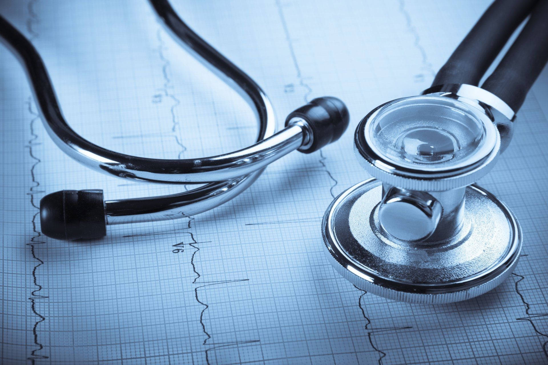 Stethoscope 桌布 壁紙 — 一個閃亮的聽診器放在顯示心跳線的藍色醫療圖表紙上。