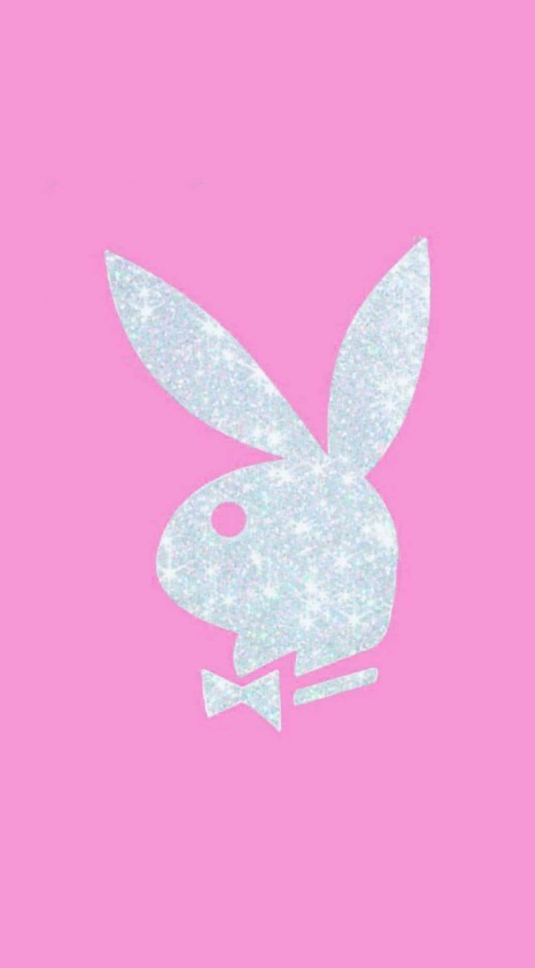 Playboy Aesthetic 桌布 壁紙 — 一個閃閃發光的銀色Playboy兔仔標誌，帶有蝴蝶結，居中在純粉紅色背景上。