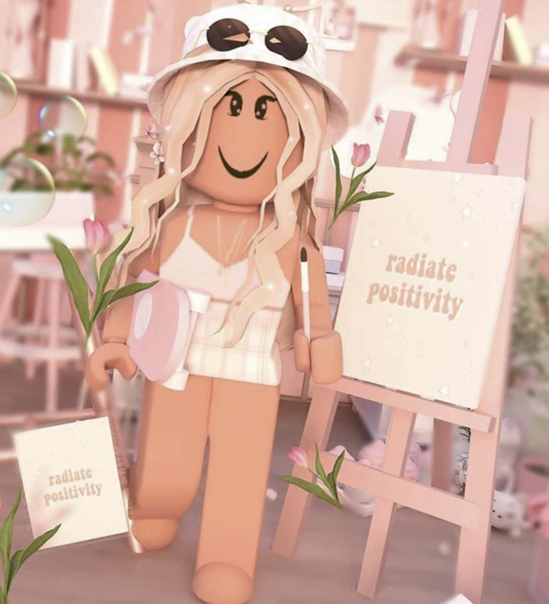 Aesthetic Roblox 桌布 壁紙 — 一個開心的Roblox頭像，金髮戴帽，站在畫架旁，畫架上有一塊畫布，上面寫著「散發正能量」，房間是粉彩粉紅色。