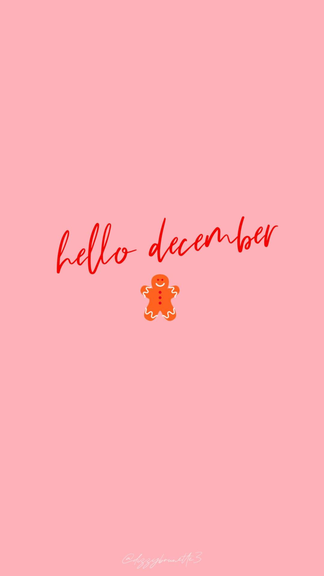 Hello December Gingerbread Man 壁紙 — 一個開心的薑餅人在柔和的粉紅色背景上，紅色草書文字hello December下方微笑。