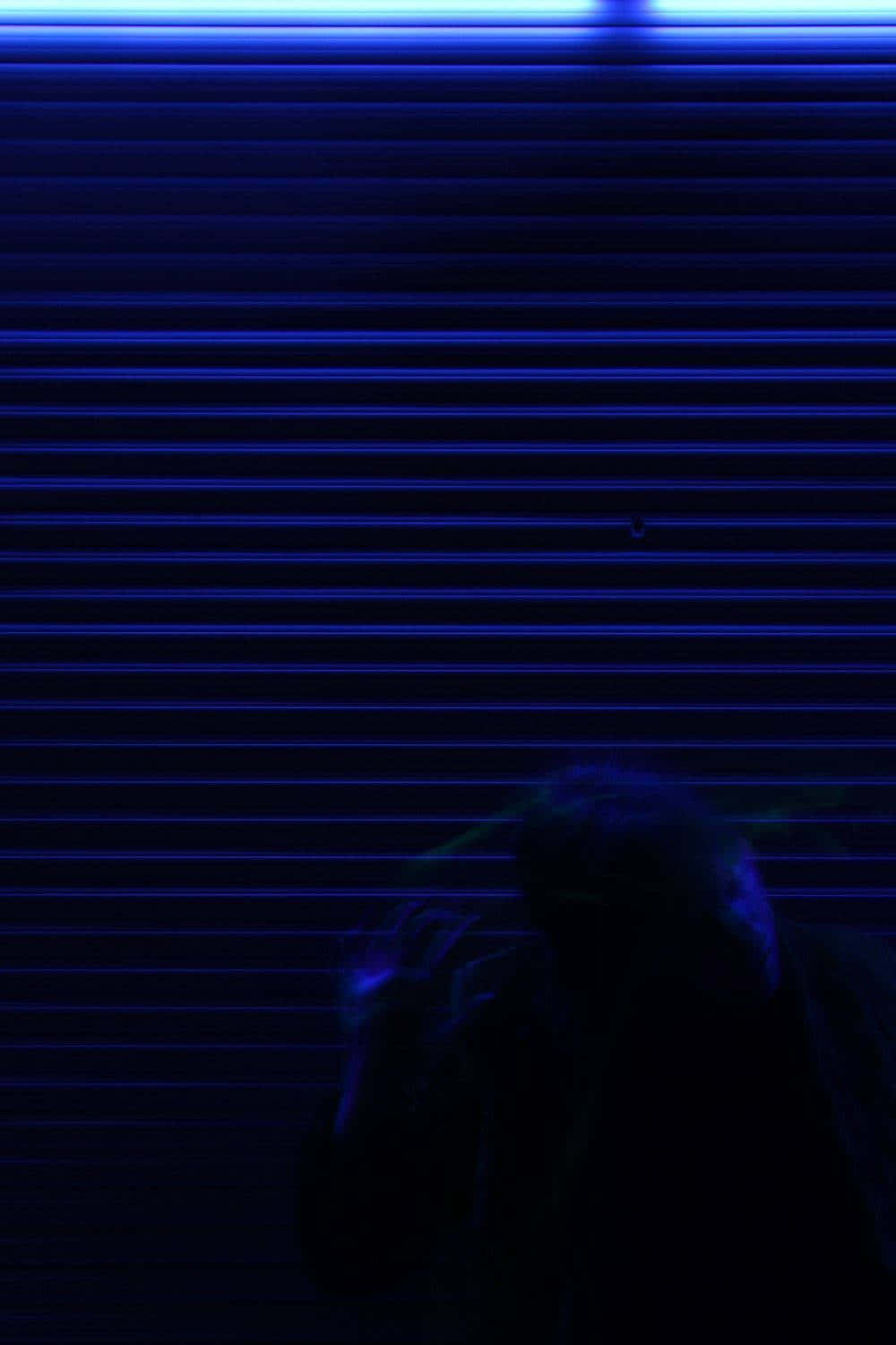 螢光藍 桌布 壁紙 — 一個陰暗的身影站在霓虹燈下發光的藍色捲簾前。