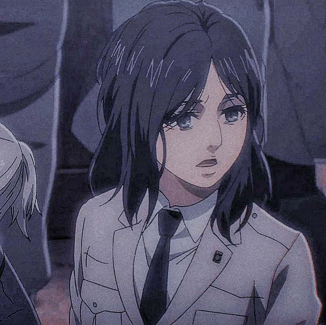 Pieck Finger 桌布 壁紙 — 一個陰鬱的動漫女孩，深色頭髮，穿著校服，在昏暗燈光下帶著憂鬱的表情低頭。