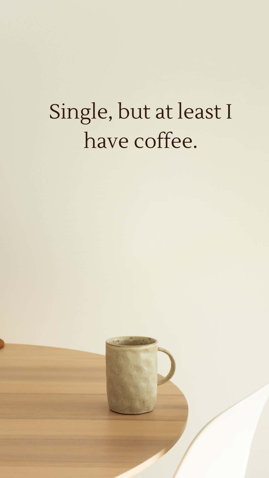 Single 桌布 壁紙 — 一個陶瓷咖啡杯放在木桌上，上方有極簡文字寫著「單身，但至少我有咖啡。」