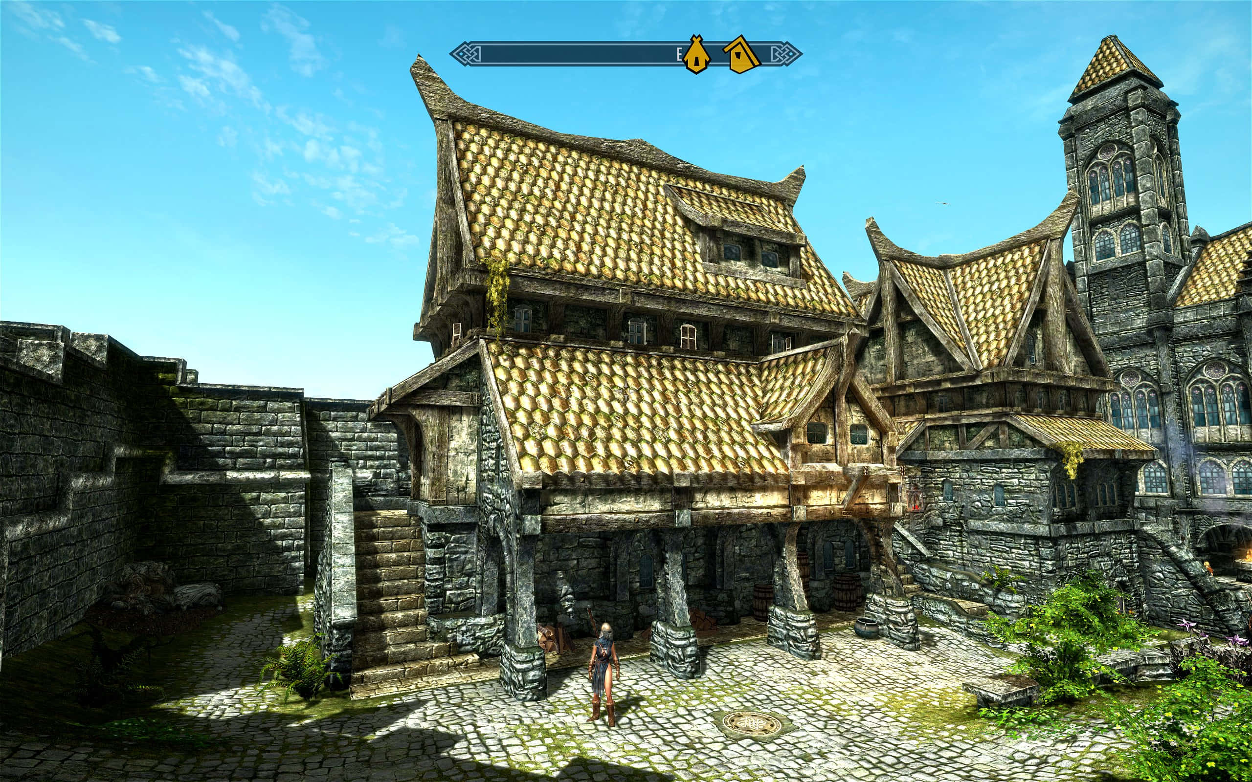 Skyrim Solitude 桌布 壁紙 — 一個陽光普照的中世紀奇幻小鎮，金色瓦片屋頂和石頭建築在清澈的藍天下。