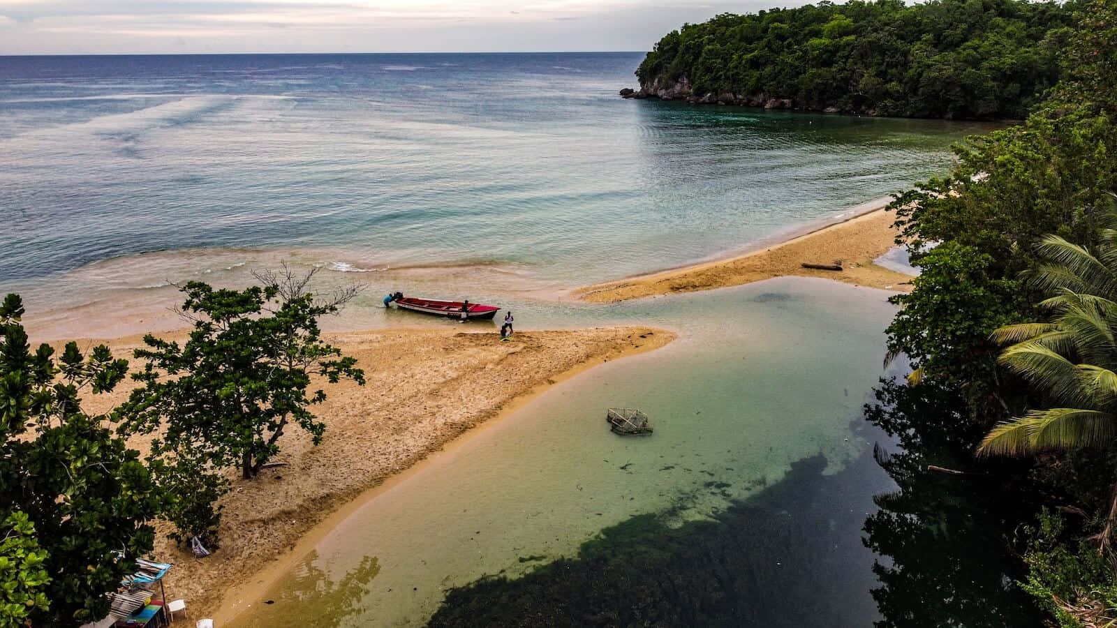 Jamaican Island 桌布 壁紙 — 一個隱蔽熱帶小海灣的鳥瞰圖，擁有碧綠色的海水、沙灘和茂密的綠色叢林環繞著海灘。