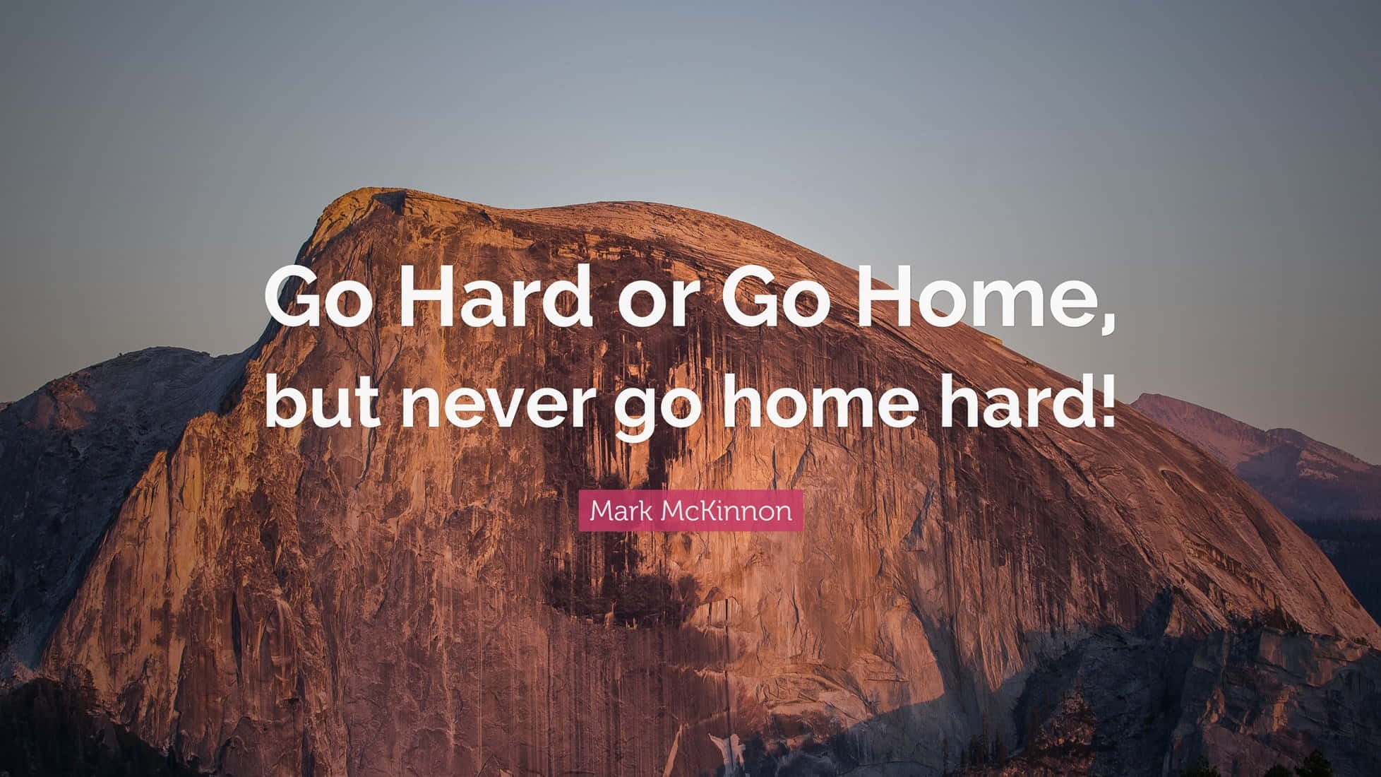 Mountains Go Hard Or Go Home 壁紙 — 一個雄偉的花崗岩圓頂沐浴在金色的日落光芒中，並疊加了一句勵志名言。