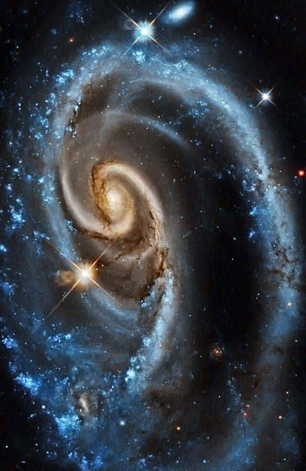 Quasar 桌布 壁紙 — 一個雄偉的螺旋星系，發光的藍色旋臂和金色核心在繁星點點的宇宙背景下旋轉。