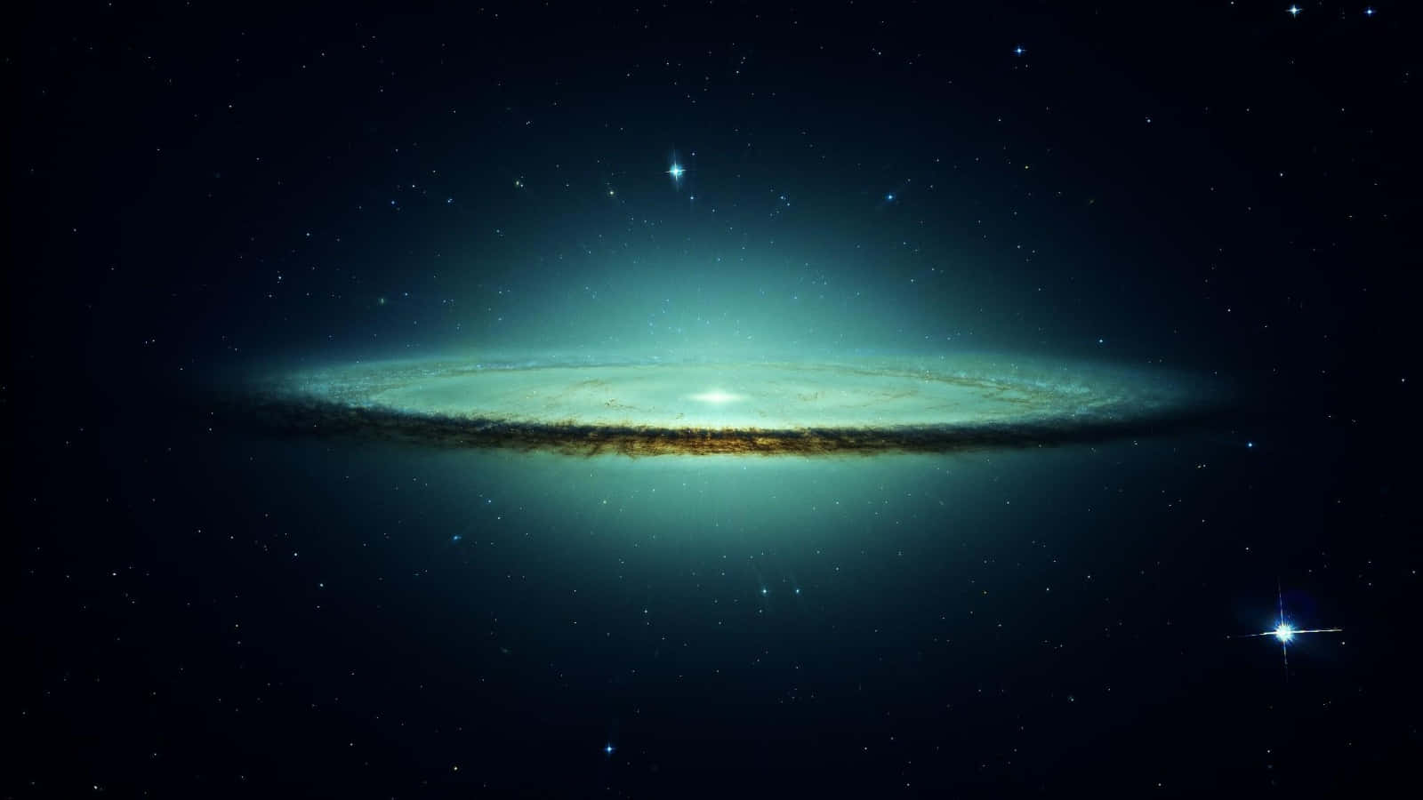 Sombrero Galaxy 桌布 壁紙 — 一個雄偉的螺旋星系在佈滿星星的宇宙虛空中閃耀著青綠色和金色的色調。