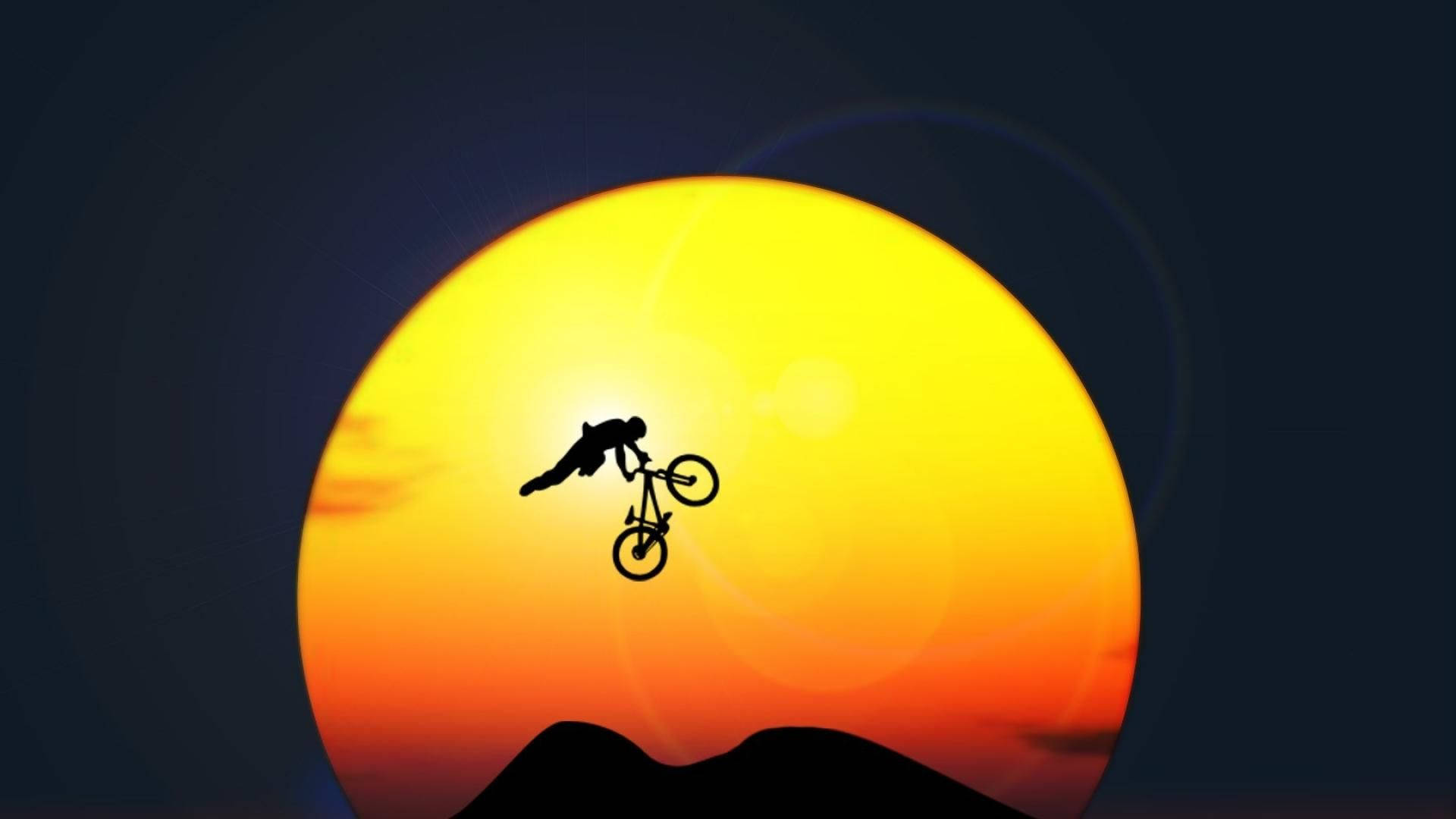 bike riding 桌布 壁紙 — 一個電單車手的剪影在山峰上巨大的發光日落前表演空中特技。