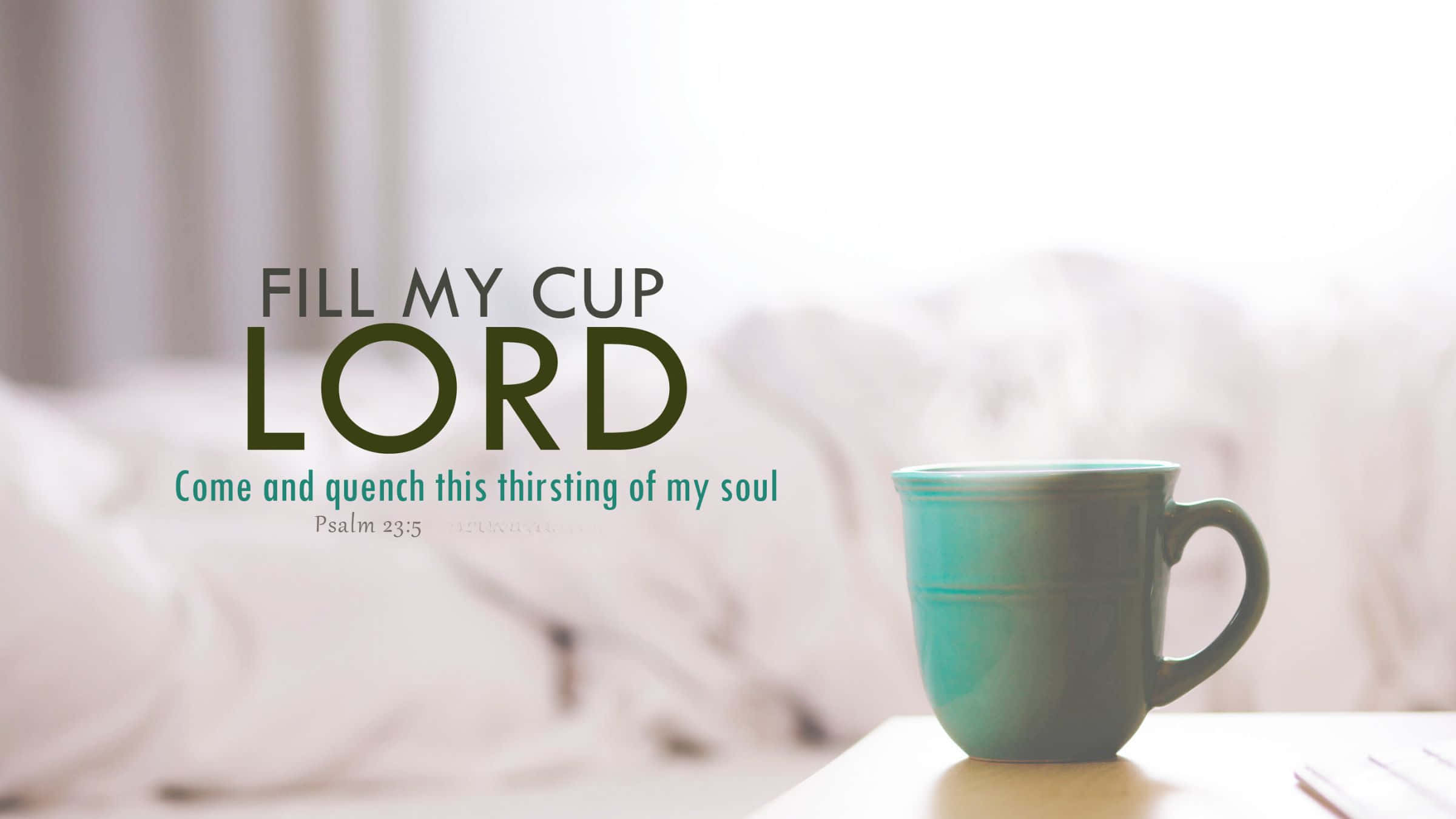 Bible Verse Desktop 桌布 壁紙 — 一個青綠色馬克杯放在木質表面上，旁邊是柔軟的白色床上用品，帶有勵志文字疊加。