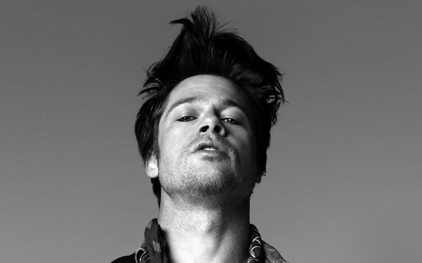 Brad Pitt 桌布 壁紙 — 一個頭髮蓬亂的男人在純灰色背景上向上看的黑白肖像。