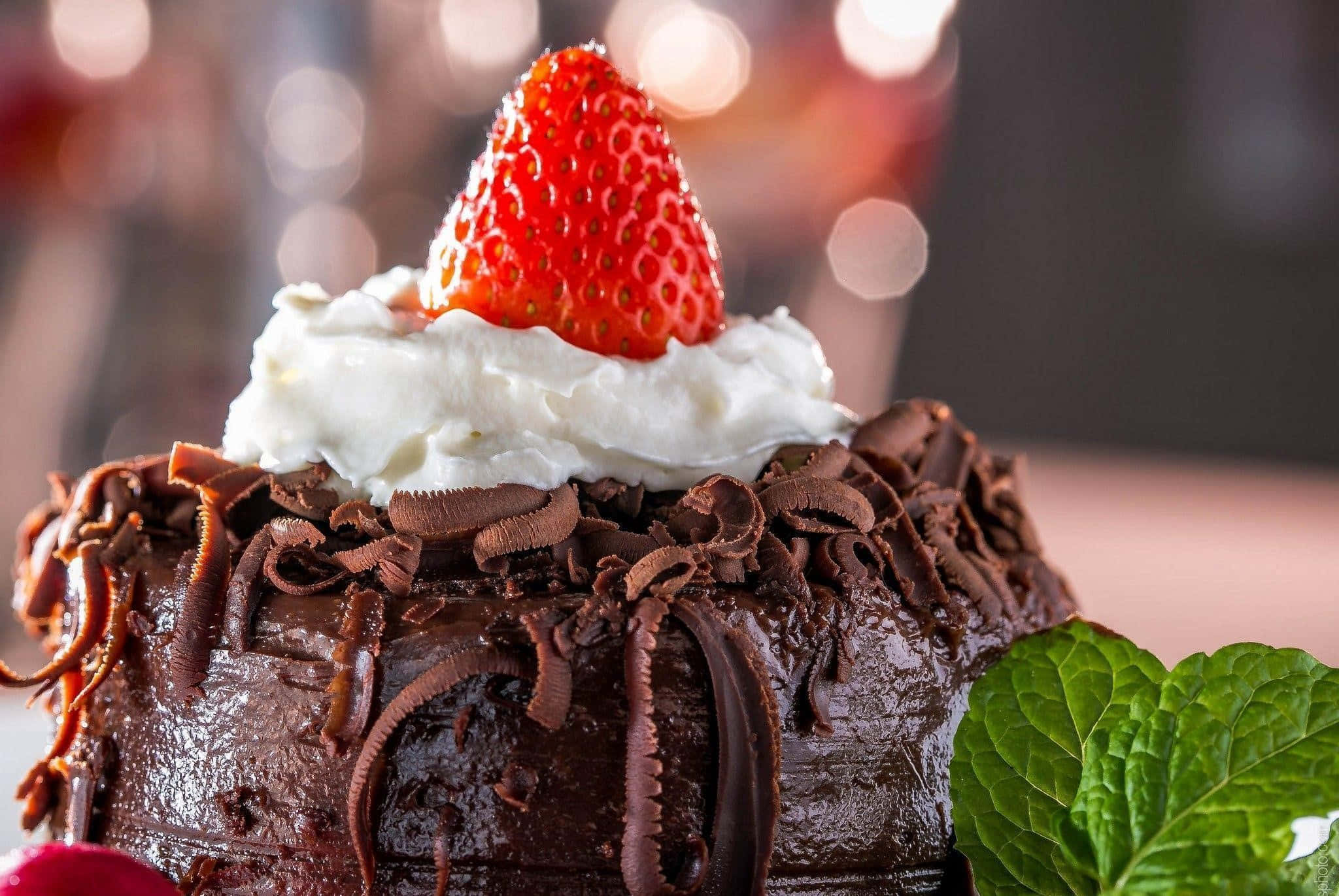Chocolate Cake 桌布 壁紙 — 一個頹廢的朱古力蛋糕，上面放著忌廉和新鮮草莓，並以薄荷裝飾。