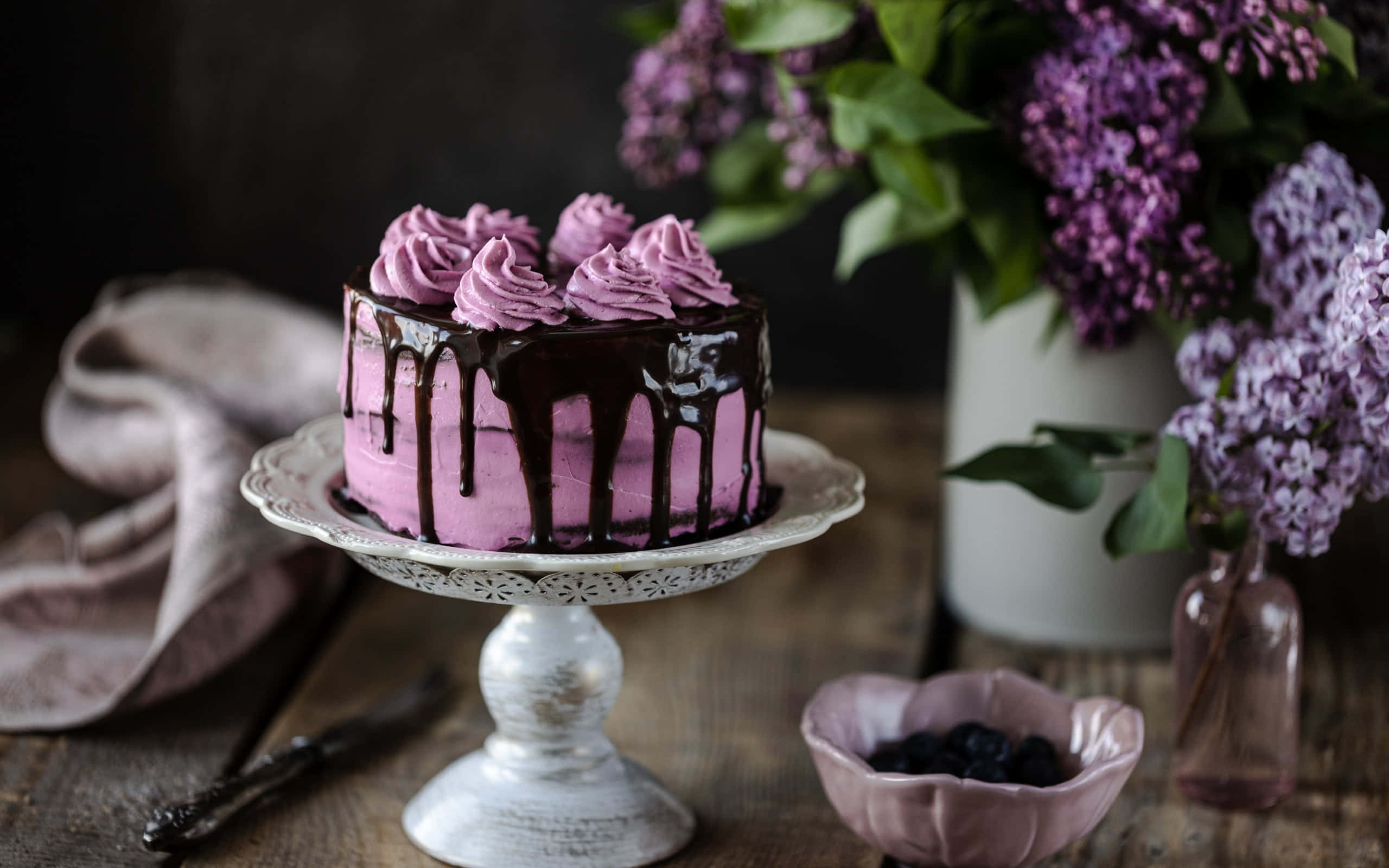 Spring Desserts 桌布 壁紙 — 一個頹廢的紫色蛋糕配上朱古力醬，放在復古架上，旁邊有丁香花和藍莓。