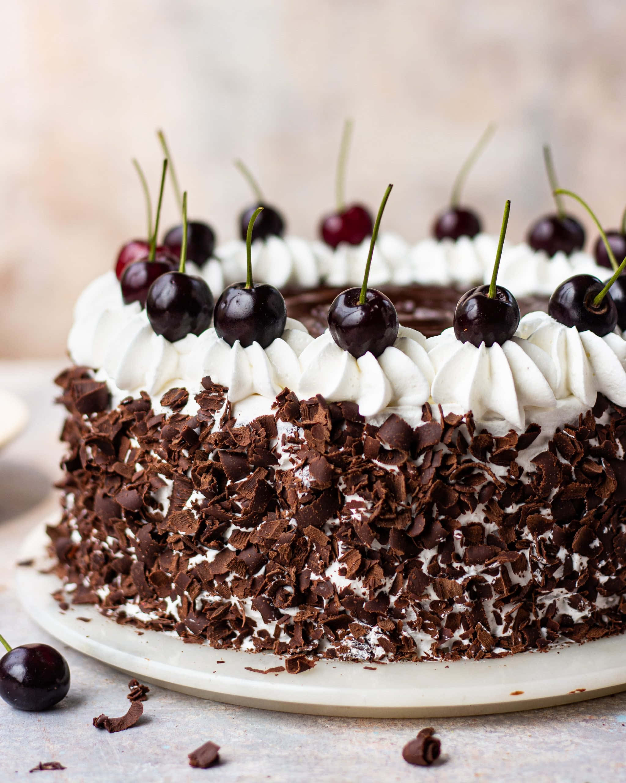 Black Forest Cake 桌布 壁紙 — 一個頹廢的黑森林蛋糕，上面裝飾著鮮奶油和光亮的櫻桃。