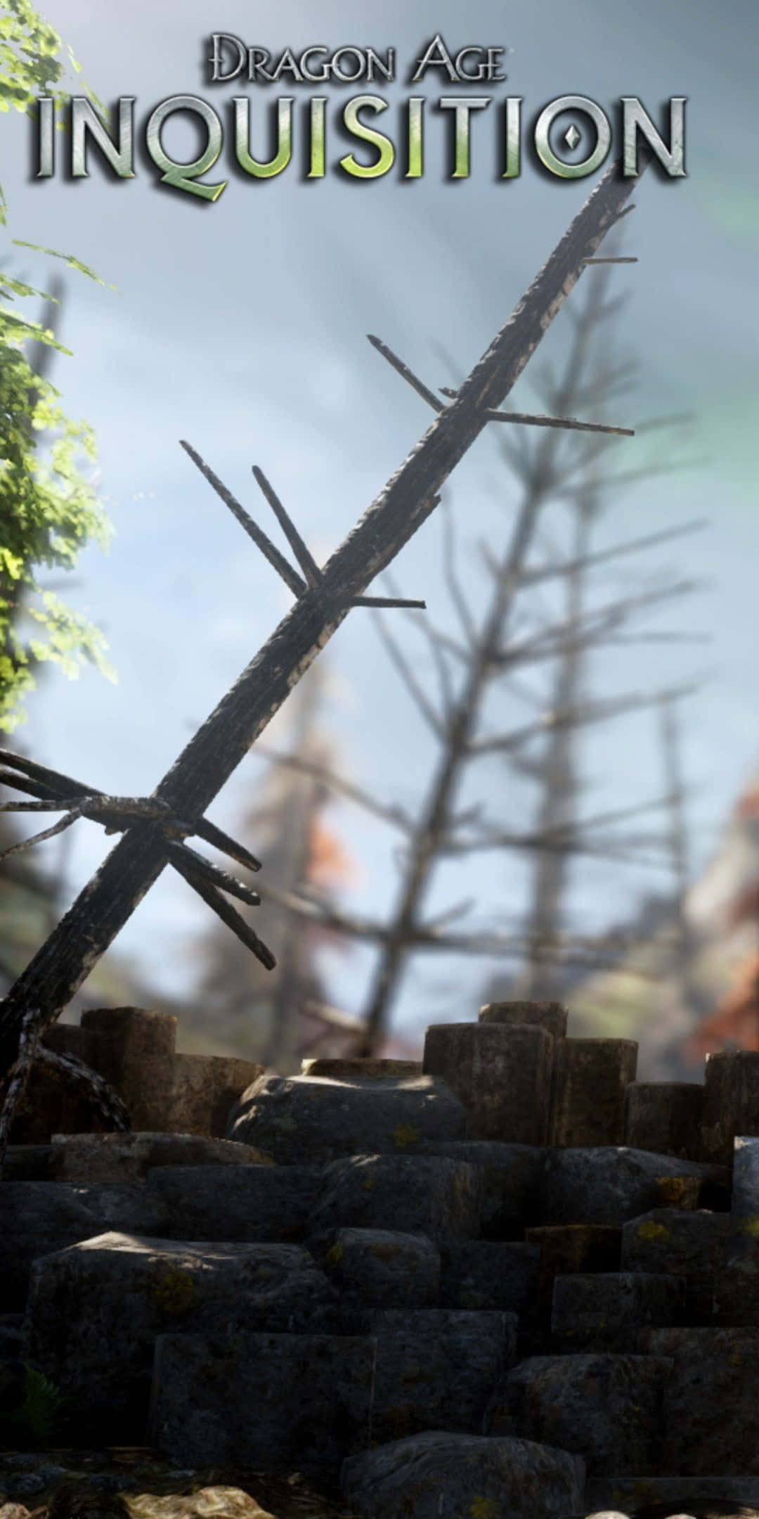 Pixel 3 Dragon Age Inquisition 桌布 壁紙 — 一個風化的木製十字架矗立在石頭廢墟上，天空朦朧，左側有綠色樹葉。