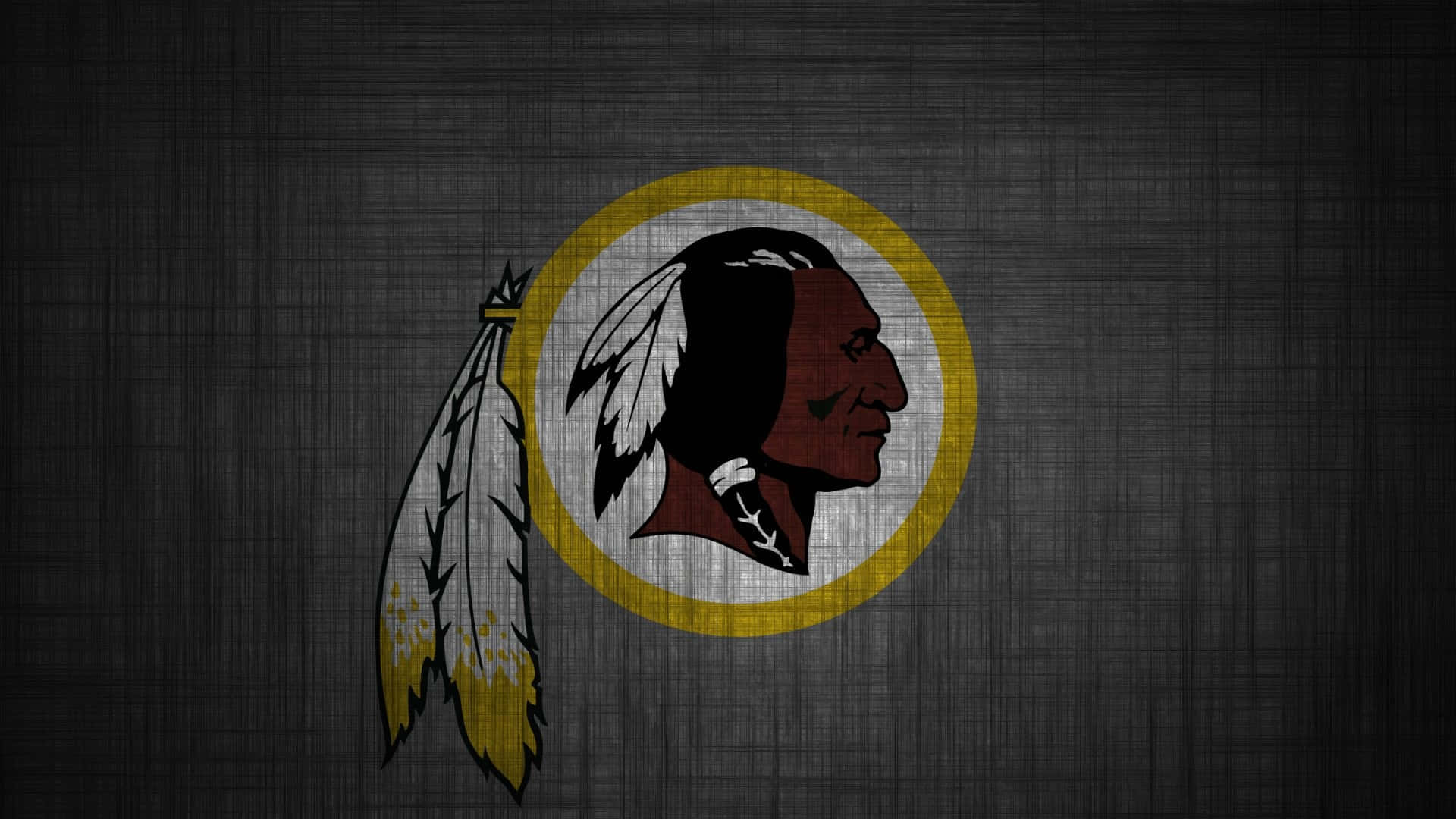 Washington Football 桌布 壁紙 — 一個風化的華盛頓指揮官標誌，帶有美洲原住民側面和羽毛，位於深色紋理背景上。