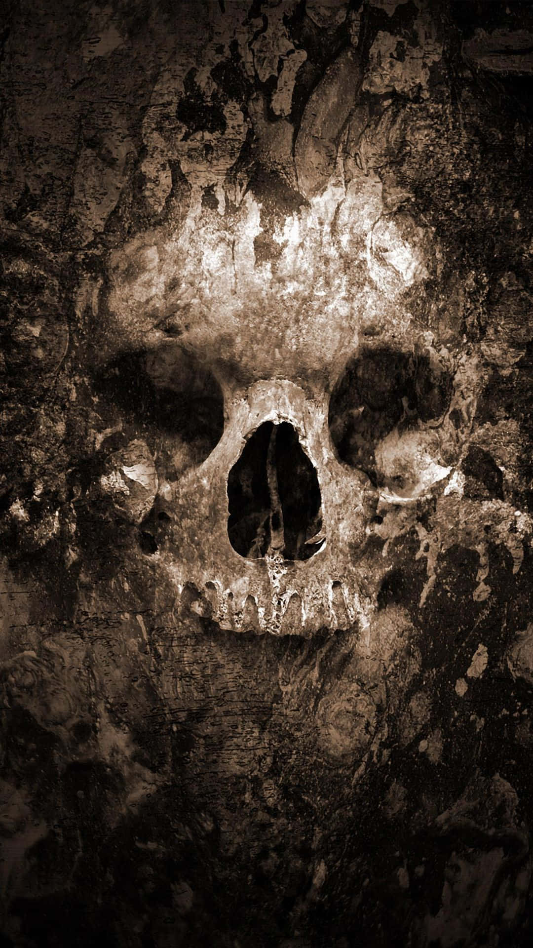 Halloween Skeleton 桌布 壁紙 — 一個風化的頭骨從龜裂的泥土表面顯現，呈現粗糙的懷舊褐色調構圖。