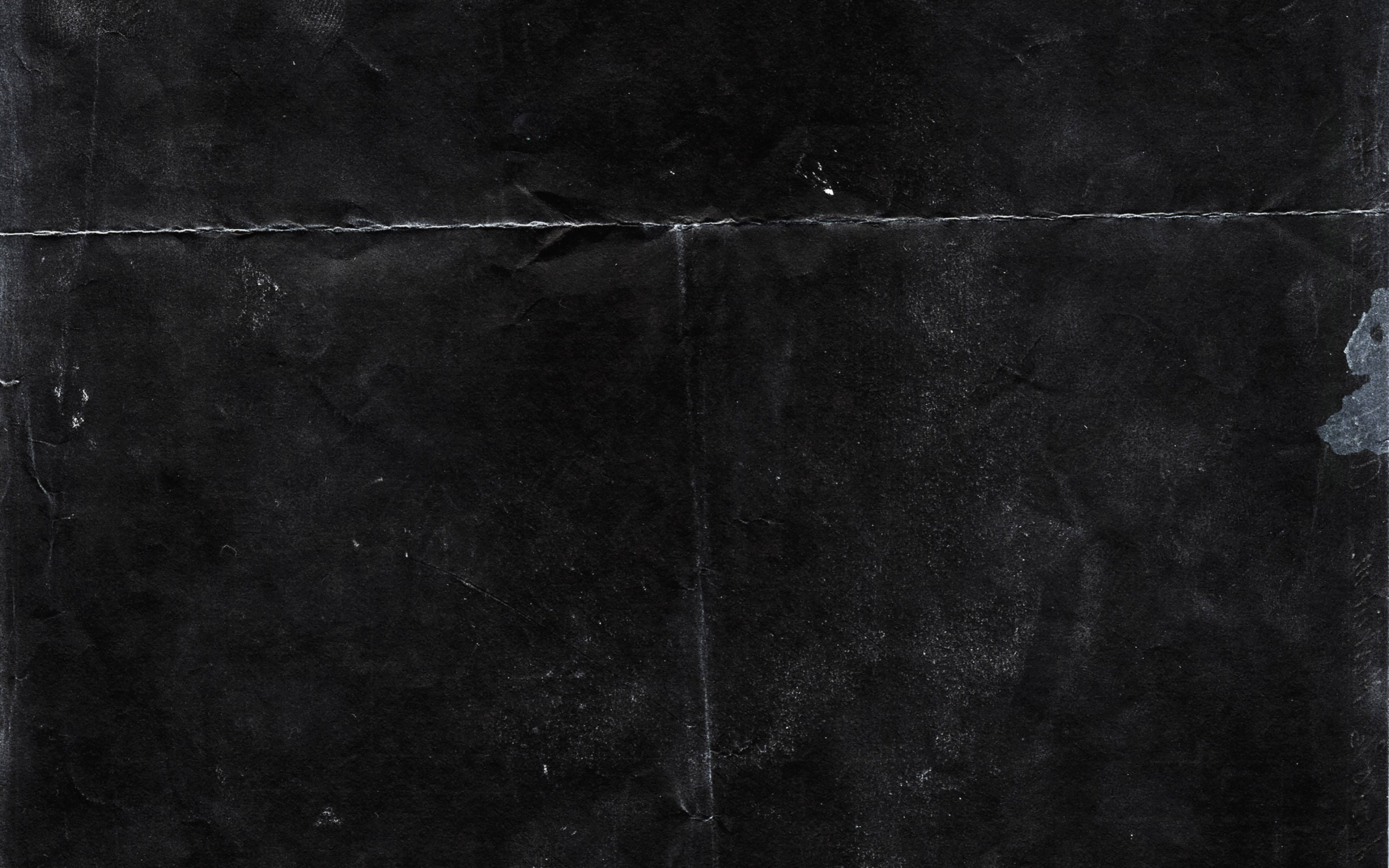 Dark Wall 桌布 壁紙 — 一個風化黑色表面的特寫，帶有微妙的紋理，在黑暗區域上有淡淡的白色刮痕。