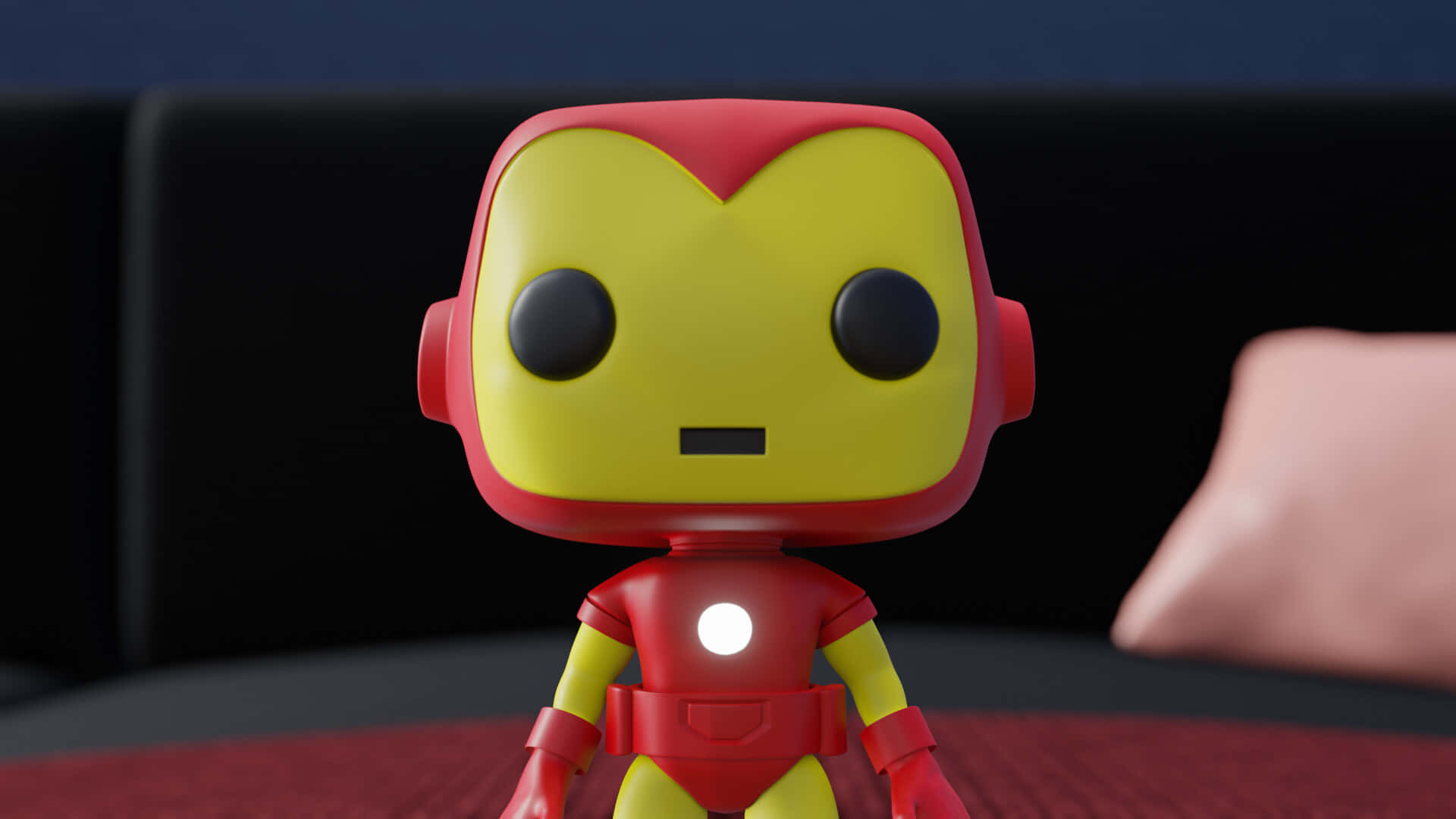 Iron Man Pop Figures 桌布 壁紙 — 一個風格化的 Iron Man Funko Pop 人偶站在紅色表面上，背景有黑色梳化和粉紅色枕頭。