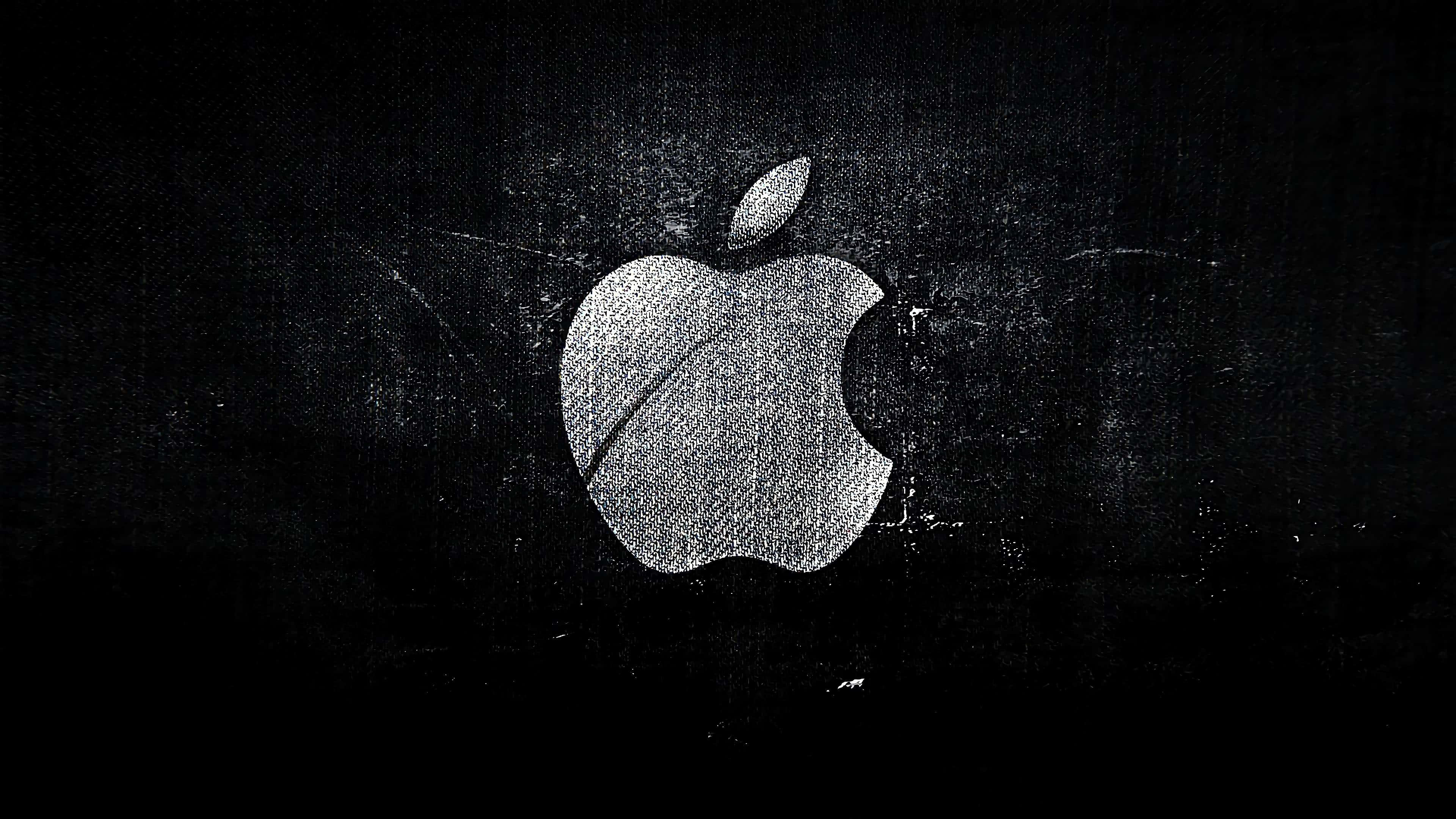 4K Apple 桌布 壁紙 — 一個風格化的Apple標誌，以銀色點狀工藝呈現在帶有刮痕的紋理黑色背景上。