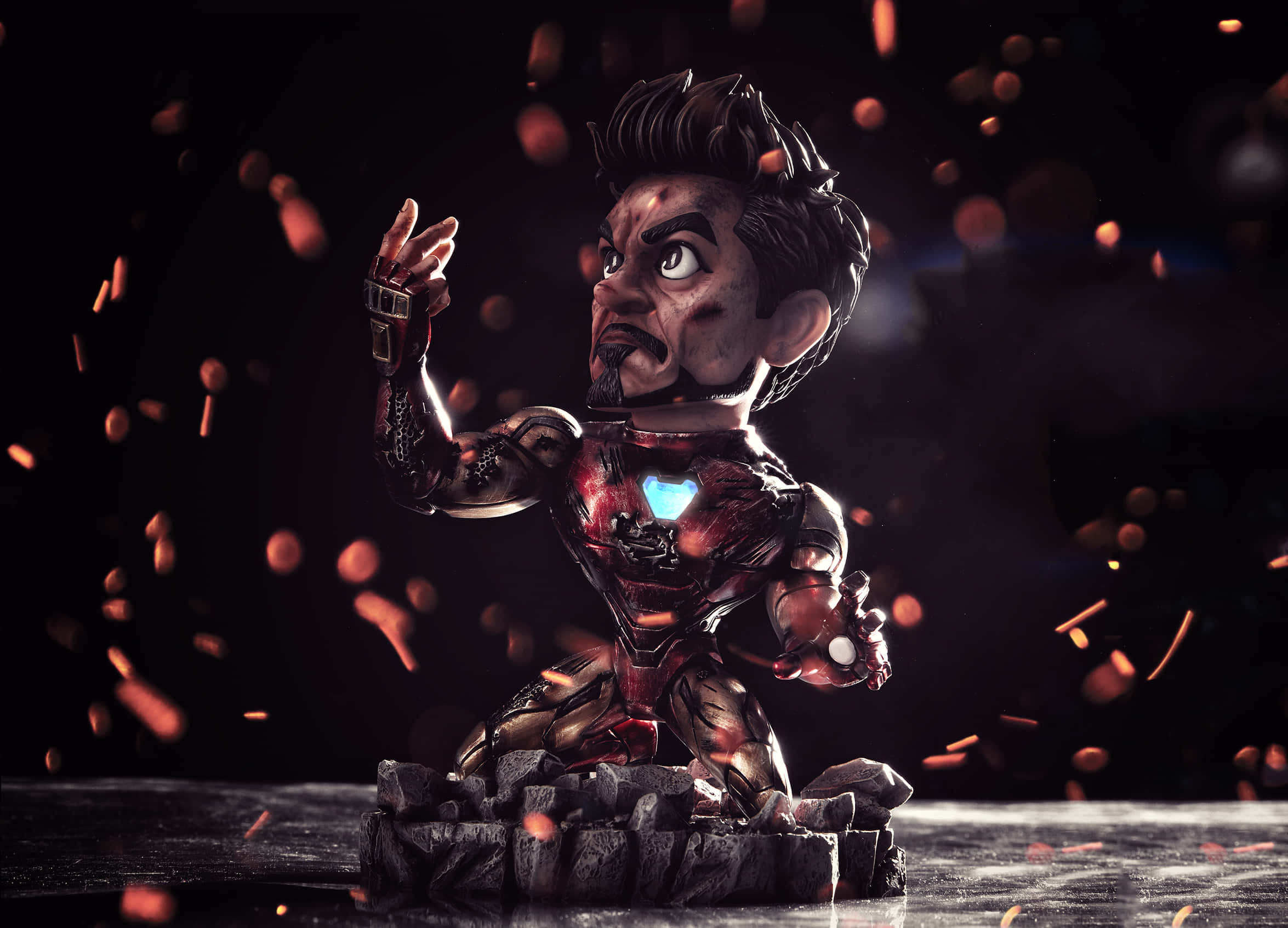 Iron Man Bobbleheads 桌布 壁紙 — 一個風格化的鐵甲奇俠人偶，帶有發光的弧形反應器和火花，背景為深色。