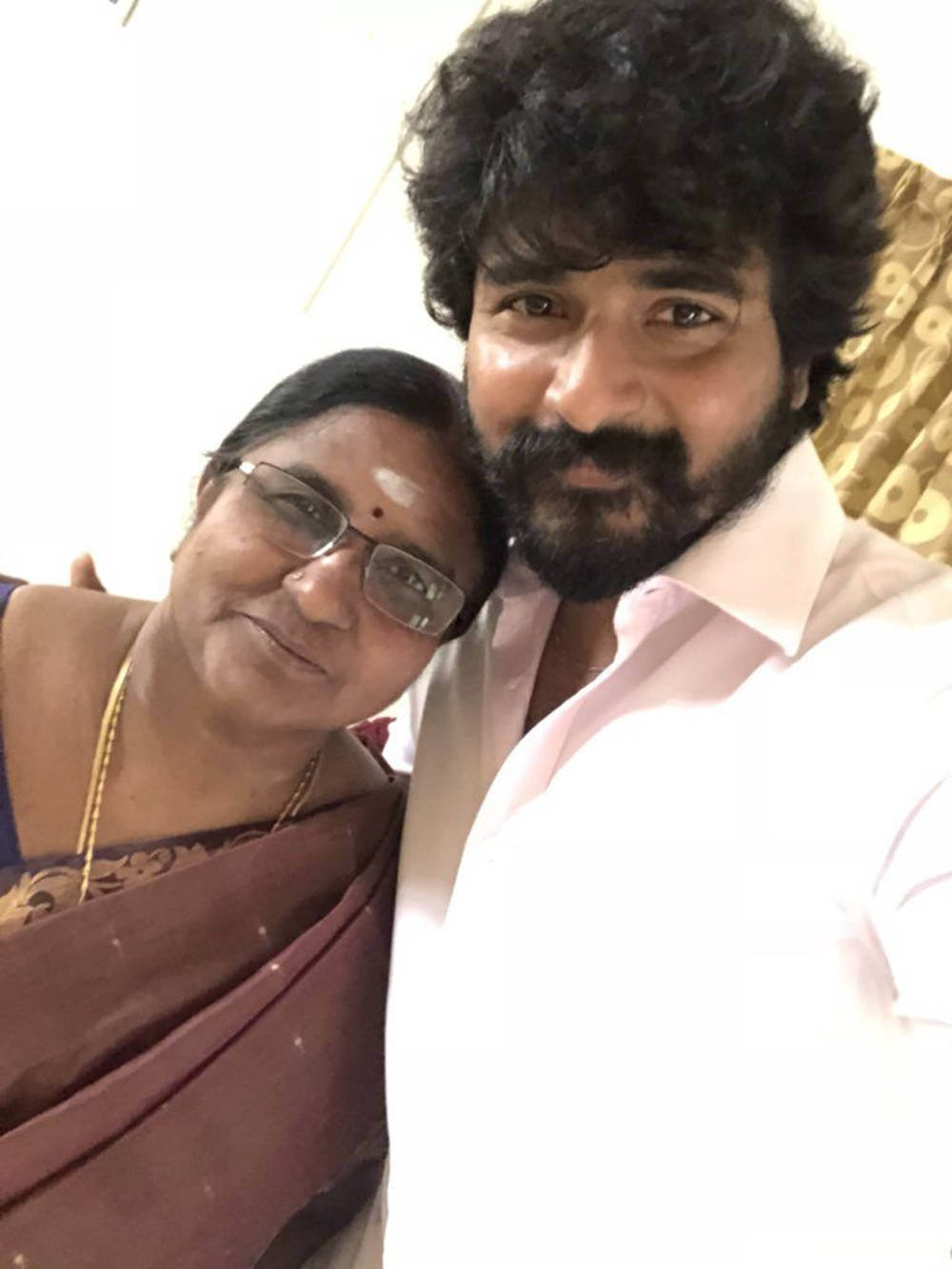 Sivakarthikeyan 桌布 壁紙 — 一個鬍鬚男人和一個戴眼鏡女人在室內緊密微笑的溫暖自拍。