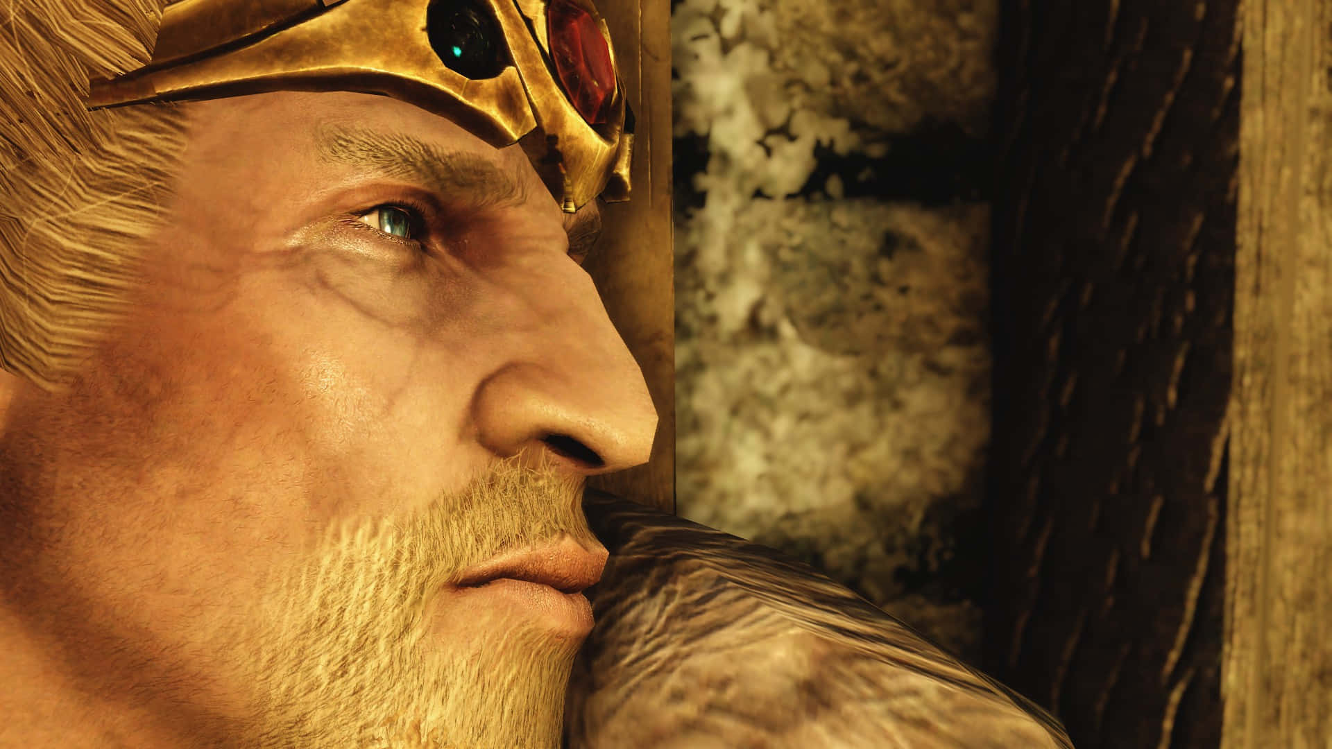 Jarl Balgruuf 桌布 壁紙 — 一個鬍鬚男人戴著鑲有發光寶石的金色頭盔，對著石牆沉思的特寫。