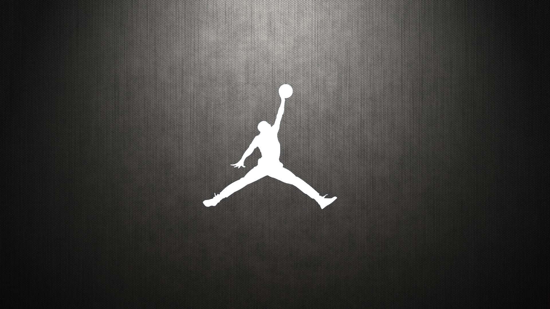 佐敦 桌布 壁紙 — 一個鮮明的白色Jordan標誌剪影，在帶有細微光線的紋理深灰色背景上躍動。