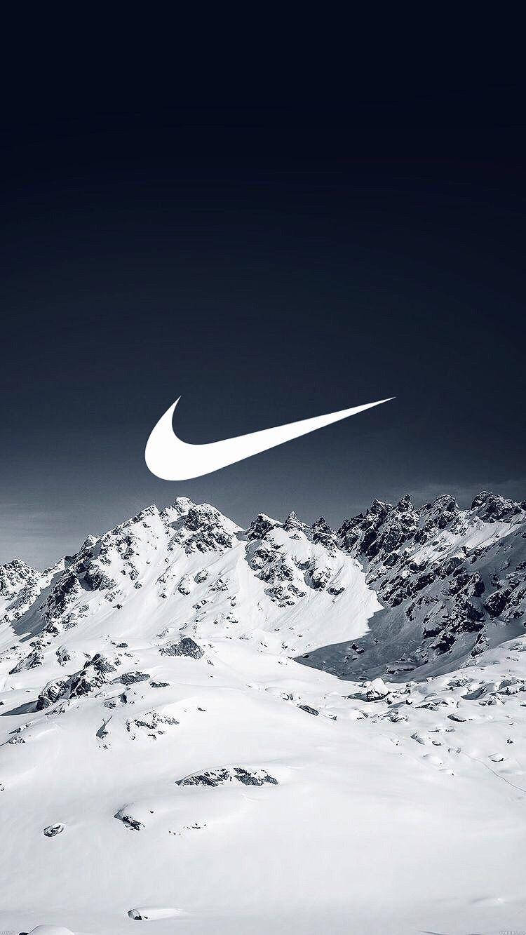 Snowy Mountain Nike iPhone Logo 壁紙 — 一個鮮明的白色Nike剔號漂浮在積雪的山脈之上，背景是深藍色的天空。