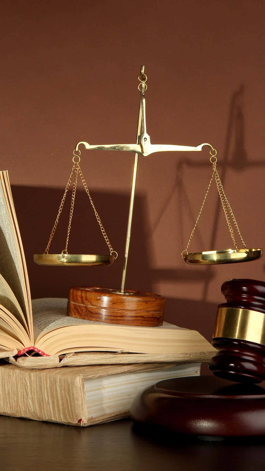 Justice 桌布 壁紙 — 一個黃銅正義天秤平衡在一本打開的法律書上，旁邊有一個木槌在深色桌子上。
