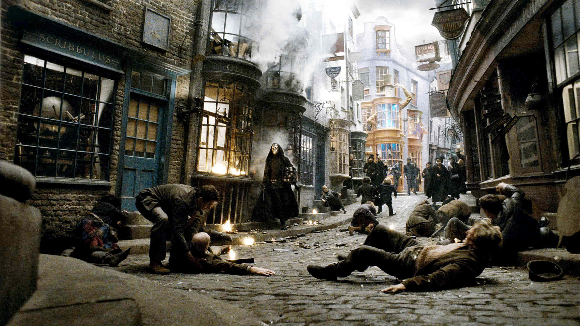 The Half-blood Prince 桌布 壁紙 — 一個黑暗巫師站在鵝卵石小巷中倒下的身影之上，建築物燃燒，煙霧升騰。