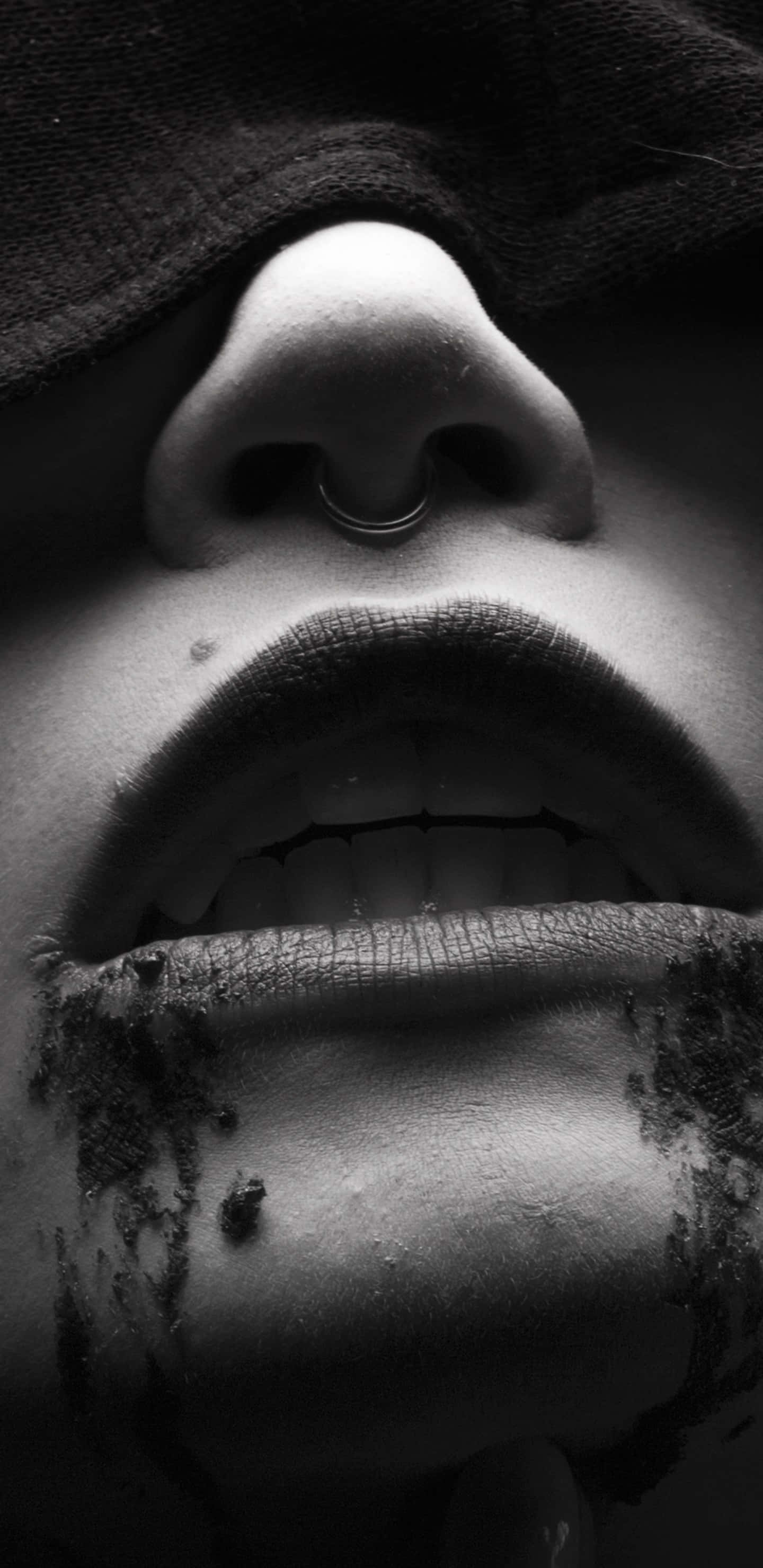 Dark Vampire 桌布 壁紙 — 一個黑白特寫，顯示一個人的臉部，戴著鼻環，嘴唇乾裂並塗有深色物質。