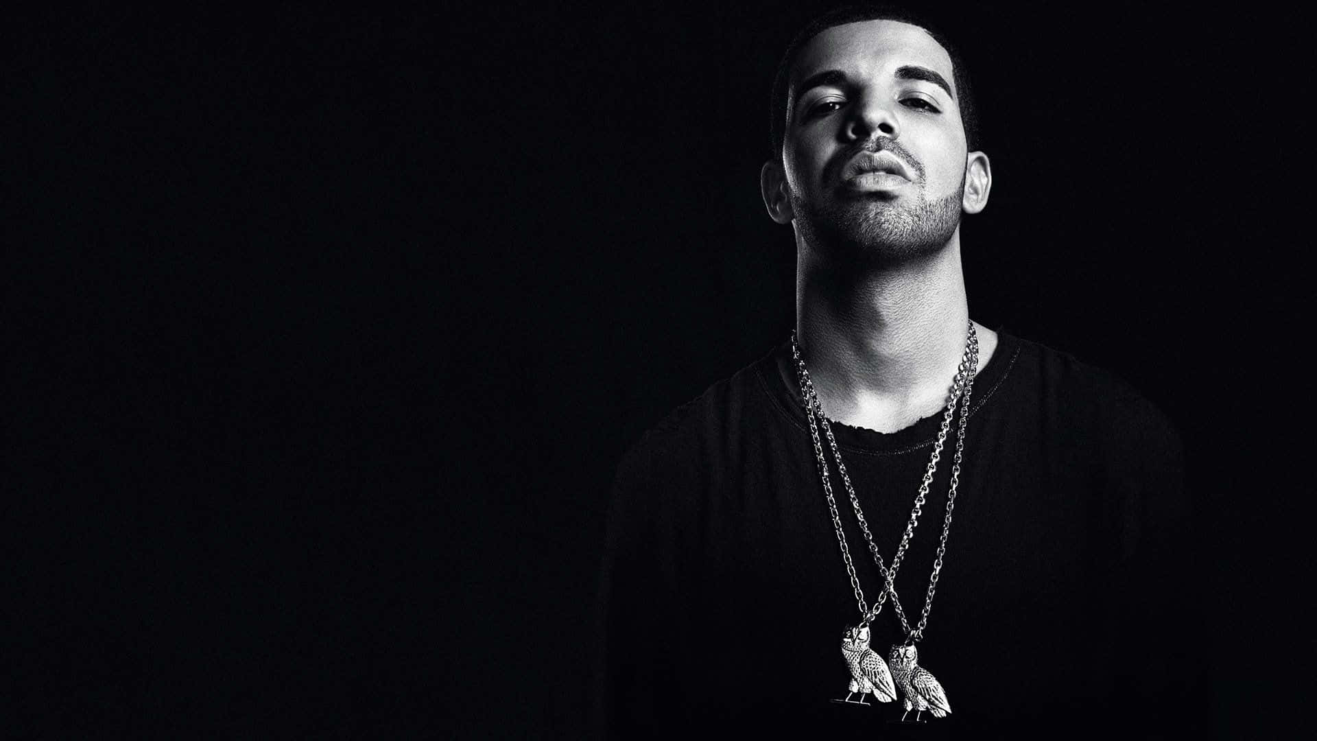 Drake 桌布 壁紙 — 一個黑白肖像，一個閉著眼睛的男人戴著貓頭鷹吊墜項鍊，背景是深色的。