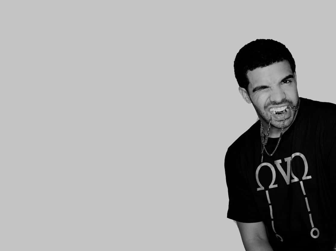 Drake 桌布 壁紙 — 一個黑白肖像，一名男子嘴裡含著一條鏈條，戴著鏈條項鍊，背景是純灰色。