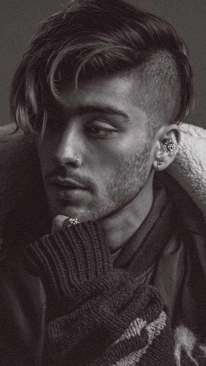One Direction 桌布 壁紙 — 一個黑白肖像，年輕男子梳理過的頭髮和臉部穿孔，下巴擱在針織毛衣上。