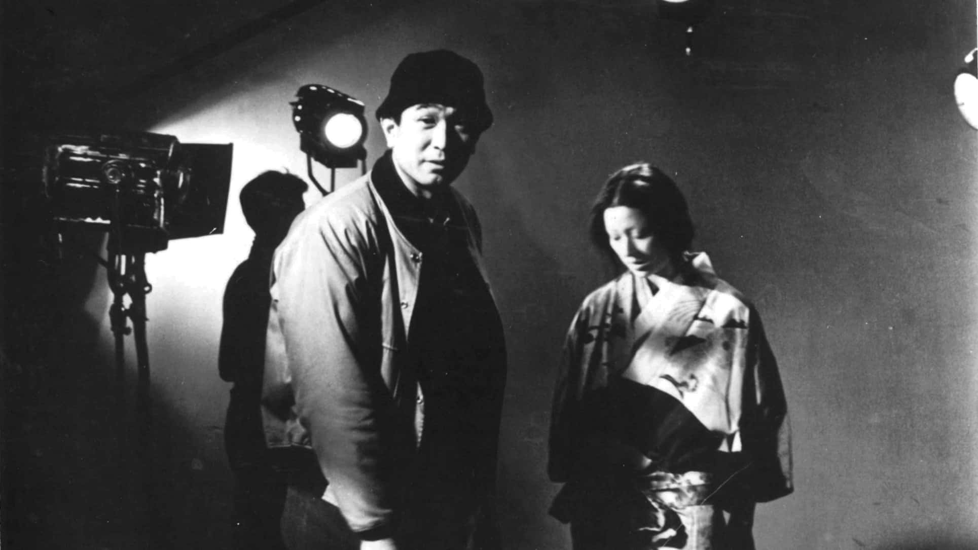 Akira Kurosawa 桌布 壁紙 — 一個黑白電影場景，有一男一女在戲劇性的攝影棚燈光下。