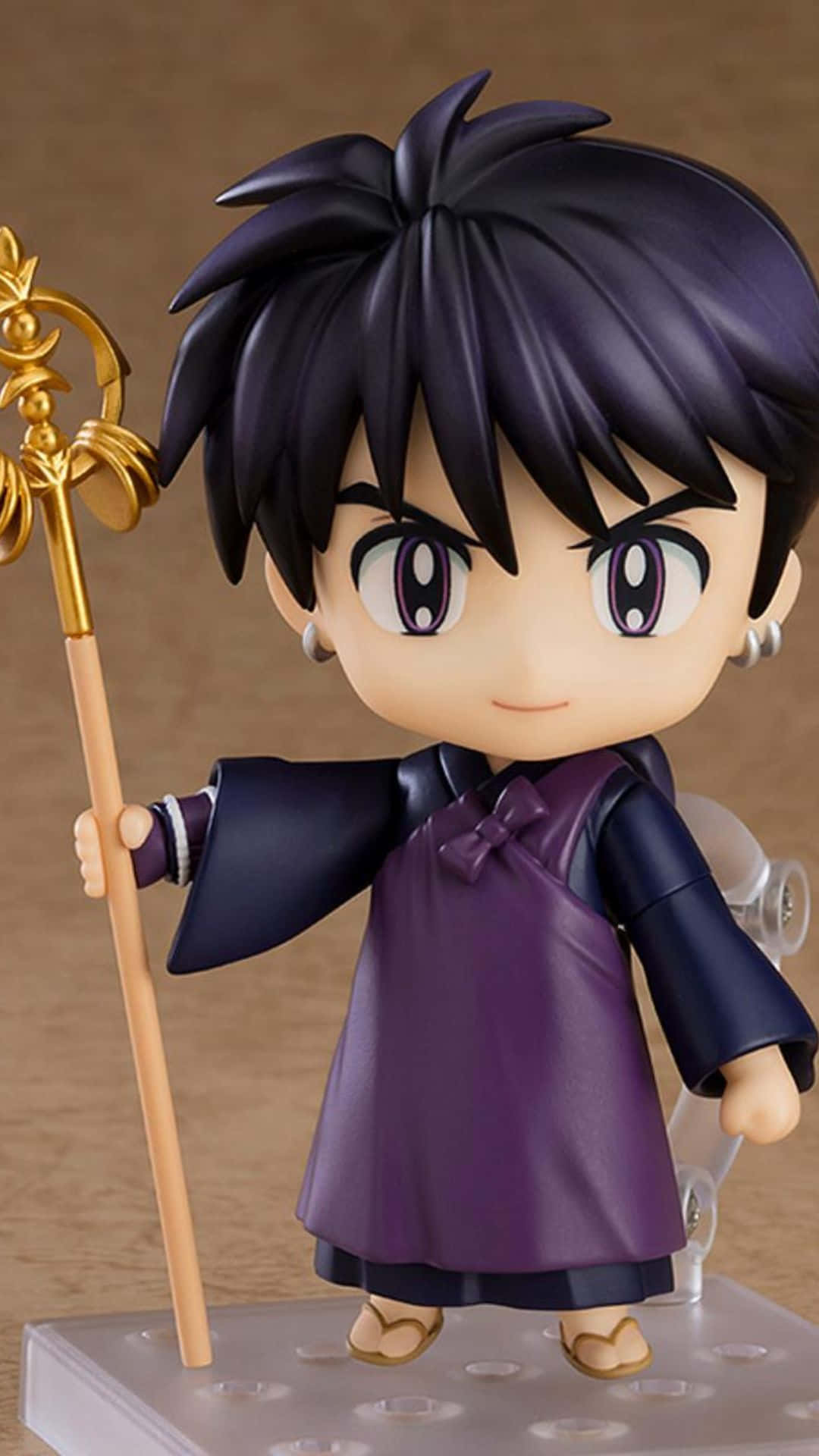 Miroku 桌布 壁紙 — 一個黑色刺蝟頭、身穿紫色服裝的Q版動漫人物，在溫暖的棕色背景前手持金色法杖。