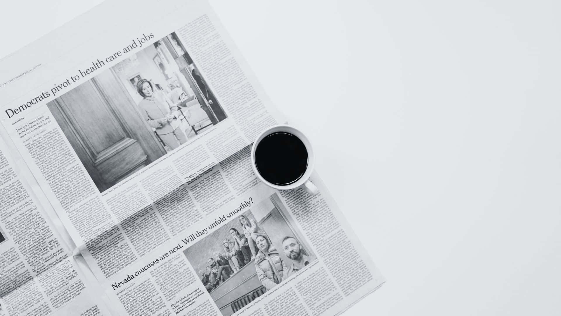 Black And White Newspaper 桌布 壁紙 — 一個黑色咖啡杯放在一個極簡白色表面上，旁邊散落著關於政治的新聞頭條。