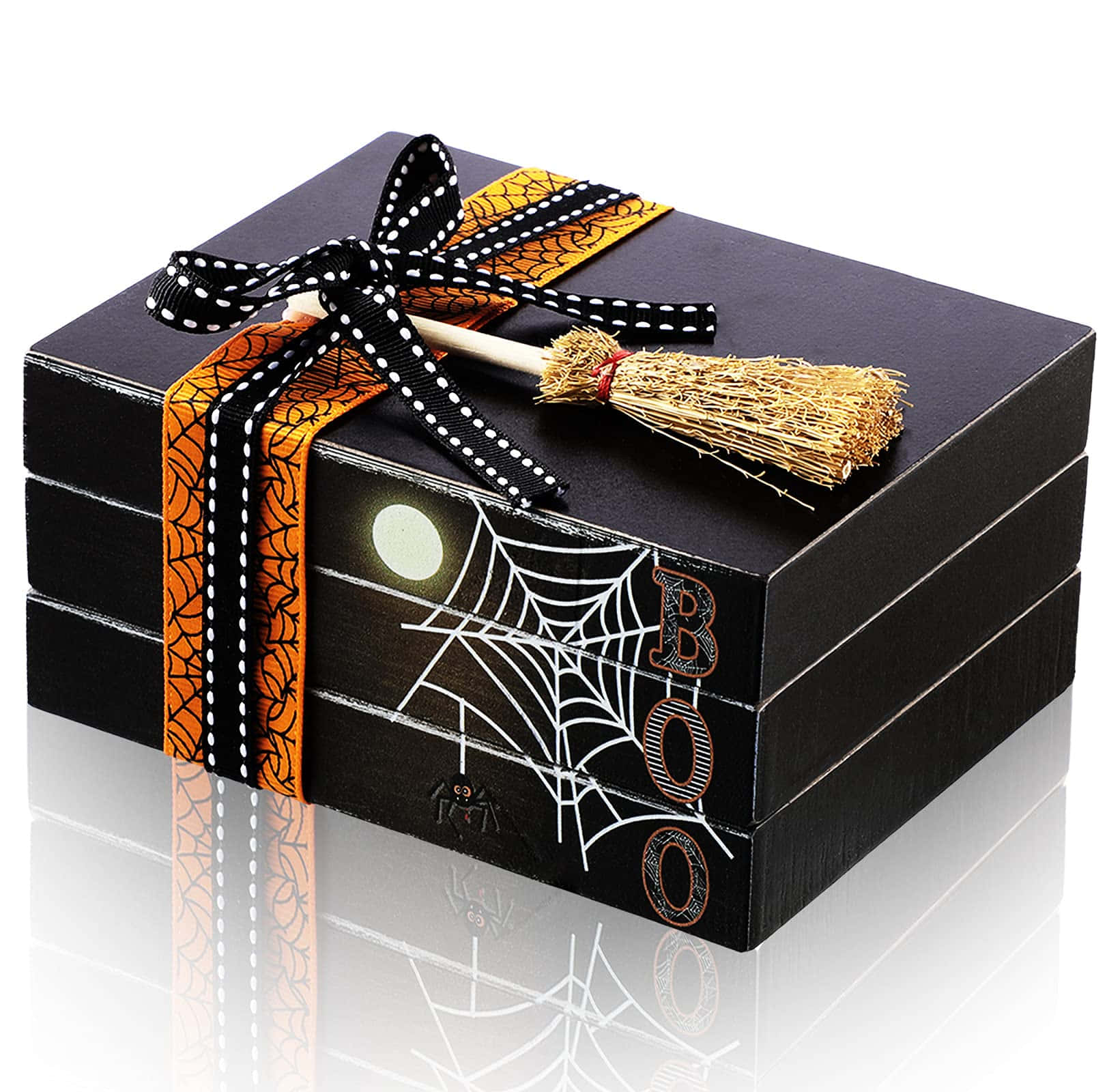 Halloween Books 桌布 壁紙 — 一個黑色萬聖節禮物盒，飾有蜘蛛網圖案、橙色絲帶、女巫掃帚和「BOO」字樣，置於反光的白色表面上。