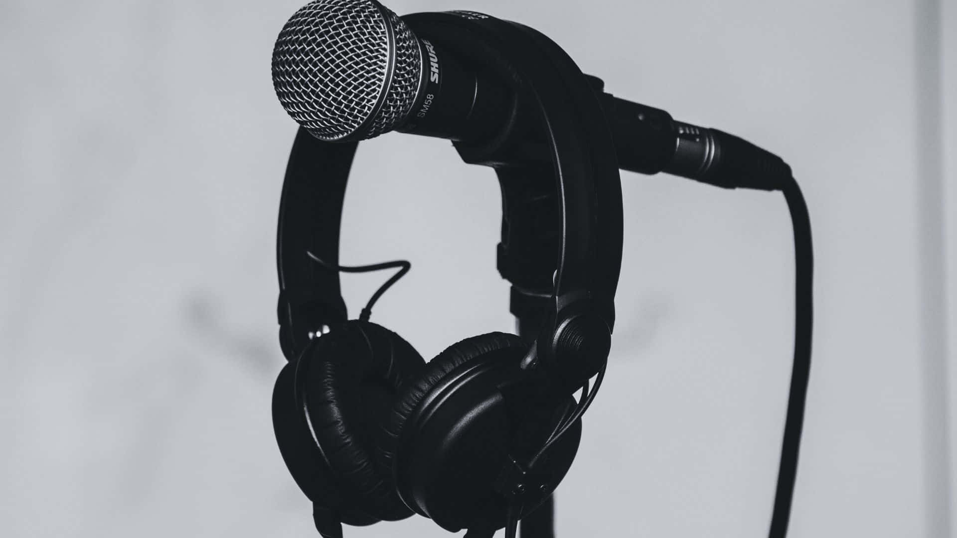 Black And White Music 桌布 壁紙 — 一個黑色錄音室麥克風和耳機一起掛在純白色背景上，呈現單色調。