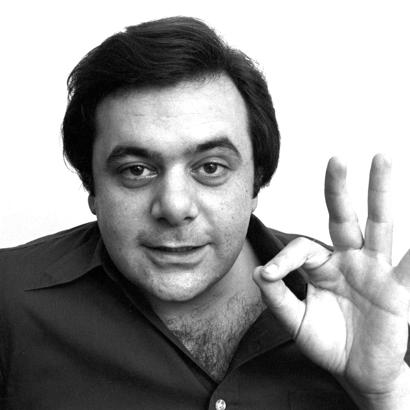Paul Sorvino 桌布 壁紙 — 一個黑髮男子在純色背景前做出「OK」手勢的黑白肖像。