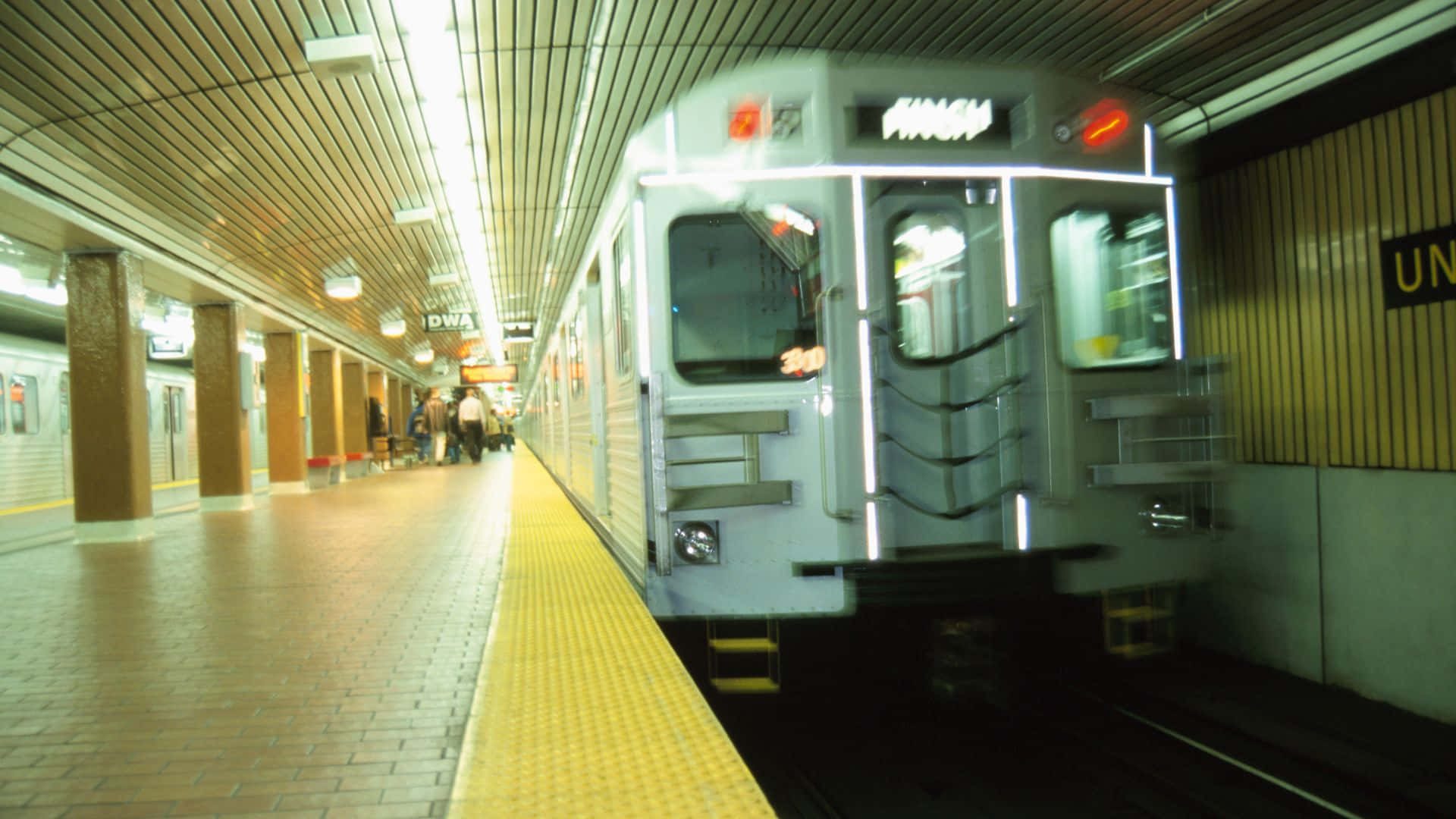 Subway 桌布 壁紙 — 一列地鐵列車在明亮的螢光燈下接近帶有黃色安全線的車站月台。