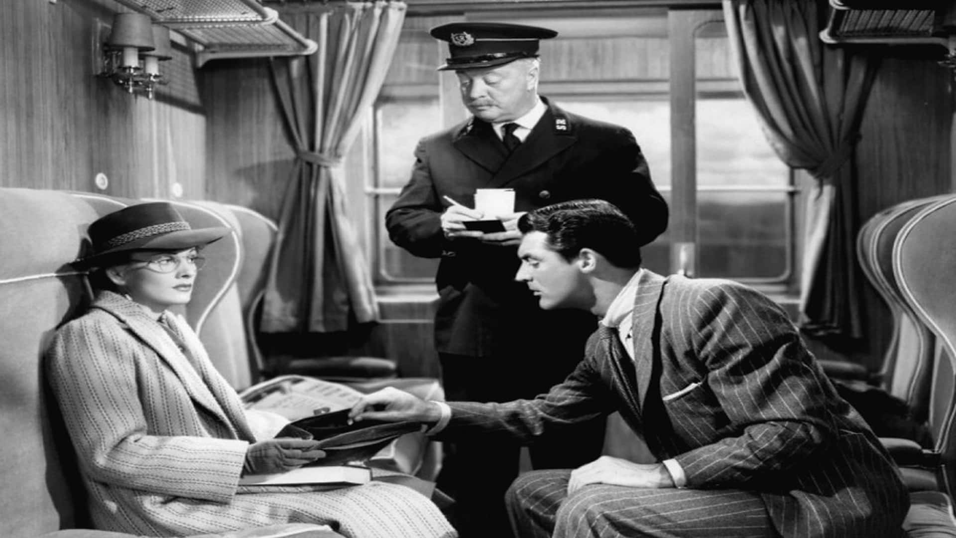 Classic Movie 桌布 壁紙 — 一列復古火車車廂內的黑白場景，一名身穿制服的列車長站在一位戴帽子的女士和一位拿著公事包、身穿細條紋西裝的男士之間。
