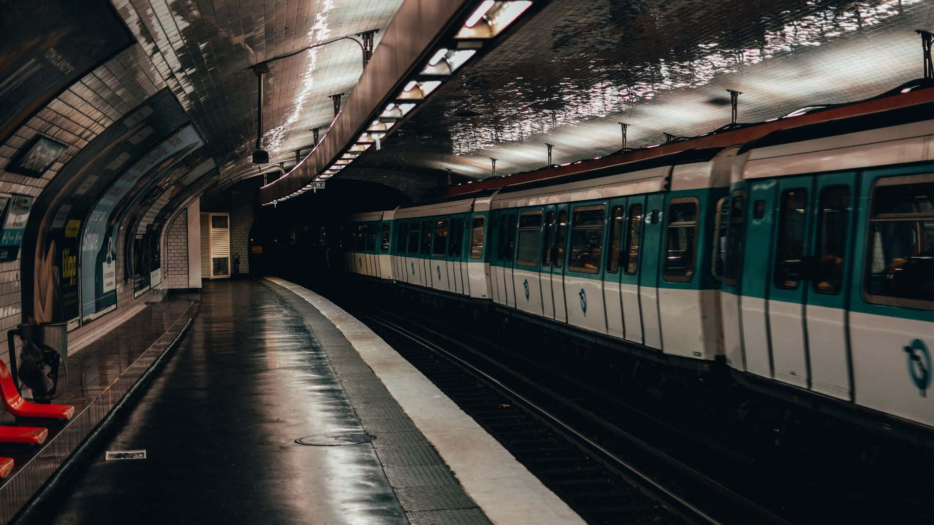 Subway 桌布 壁紙 — 一列時尚的青綠色和白色地鐵列車在光線昏暗的地下車站中滑行，車站有反光的濕潤月台和拱形天花板。