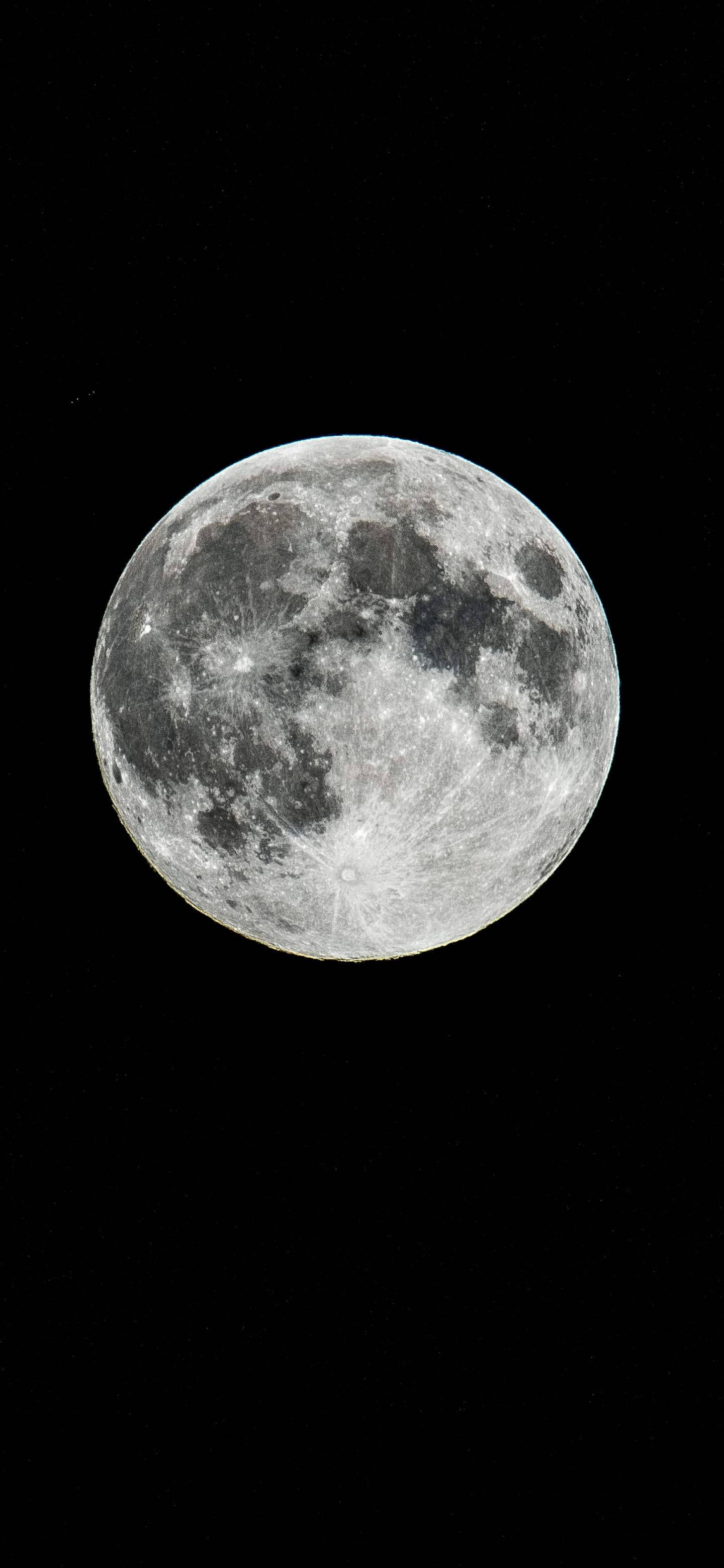 滿月，在黑暗的天空中可見隕石坑和月海。