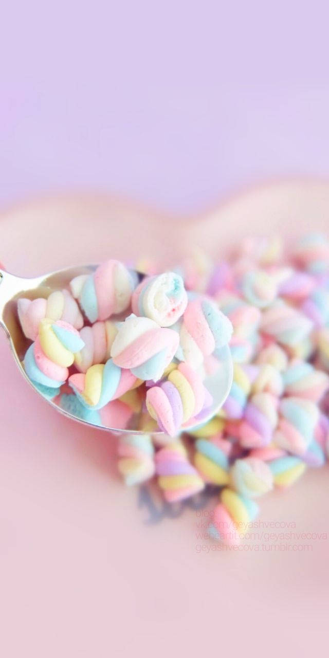 Marshmallow 桌布 壁紙 — 一匙粉彩彩虹棉花糖灑落在柔軟的粉紅色表面上，背景為薰衣草色。