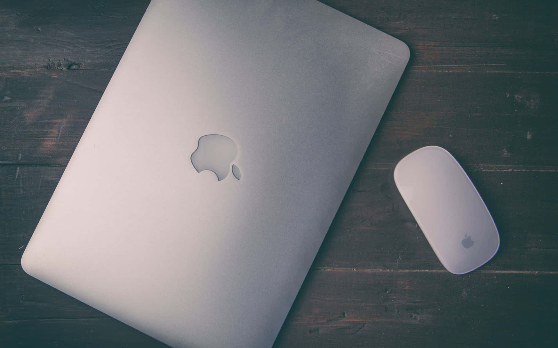 深色木桌上的銀色 MacBook 和滑鼠