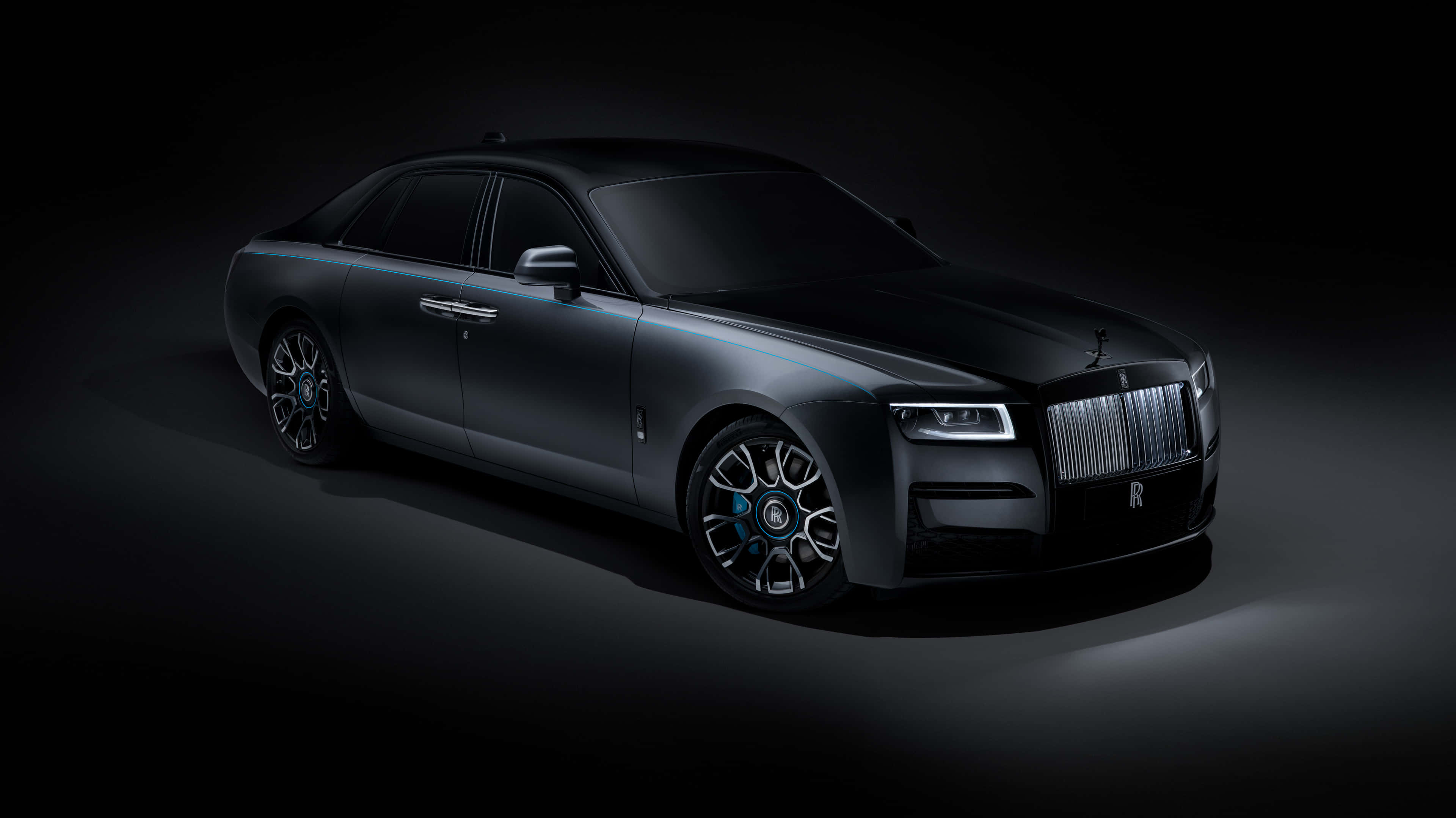 Rolls Royce 桌布 壁紙 — 一台時尚的啞光黑色勞斯萊斯幻影在戲劇性的攝影棚燈光下，在深色背景中閃耀。