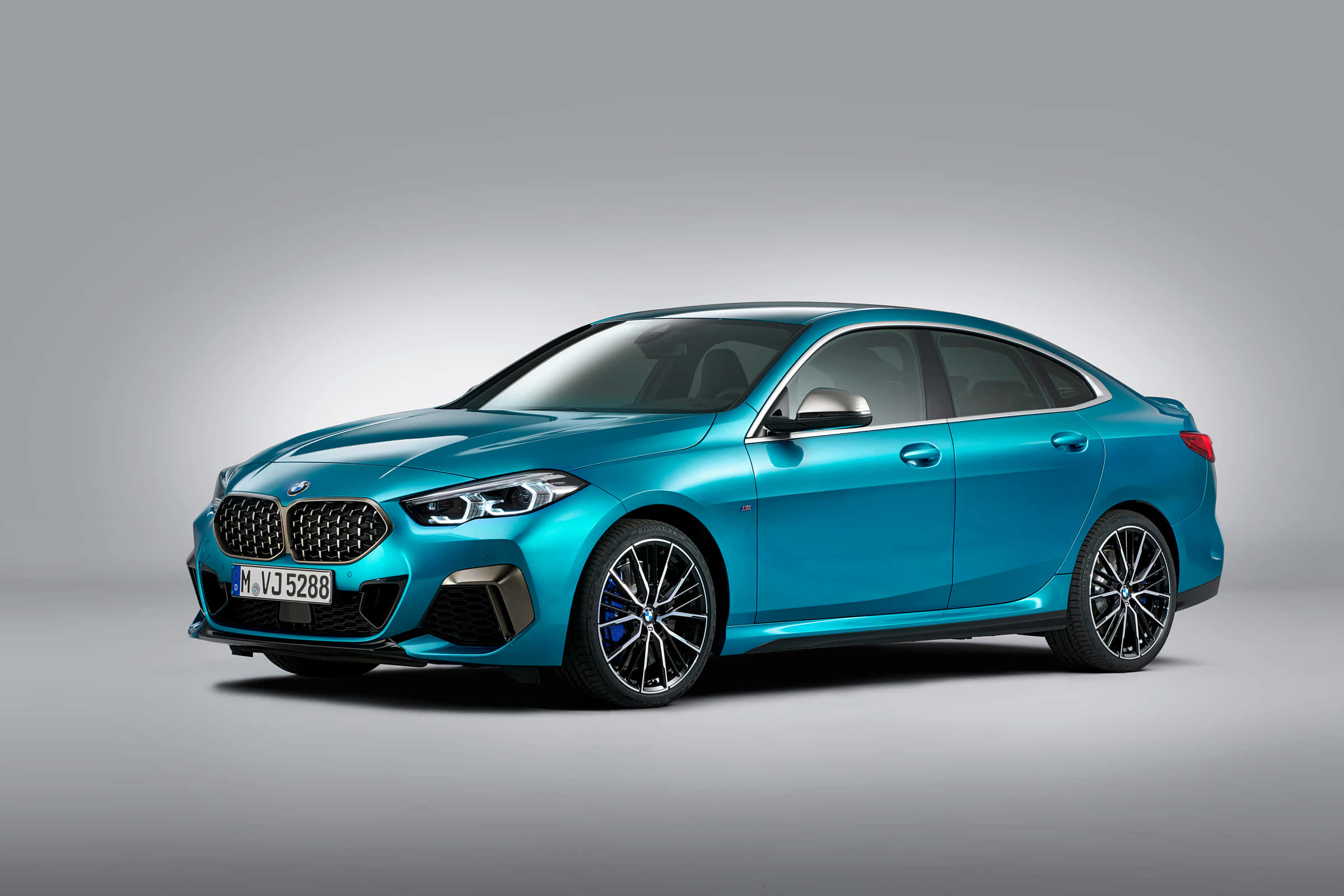 Bmw 2 Series 桌布 壁紙 — 一台時尚的綠松色BMW 2 Series Gran Coupe在攝影棚燈光下，以極簡灰色背景襯托，閃閃發光。